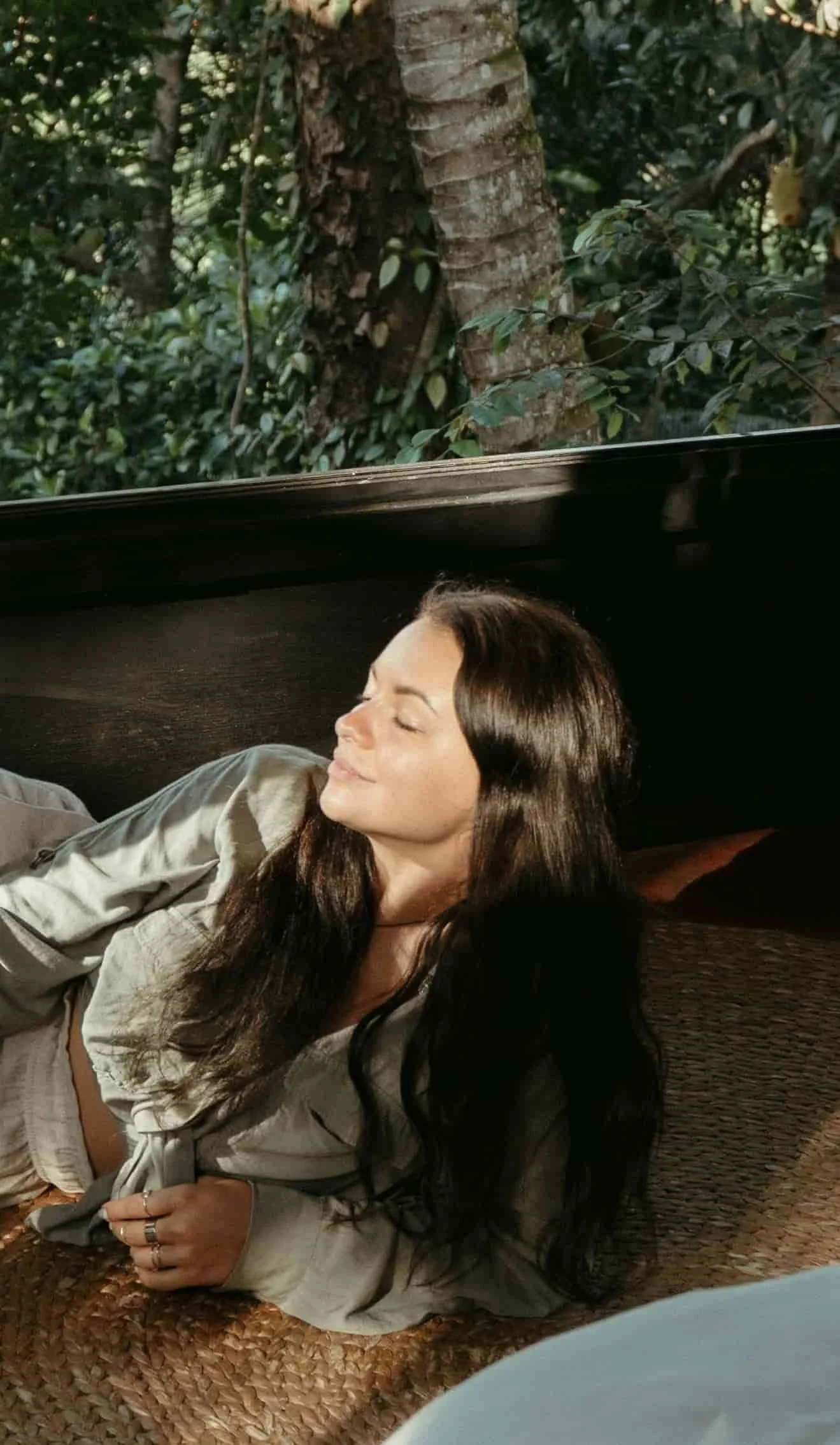woman laying on carpet and appreciating sunlight