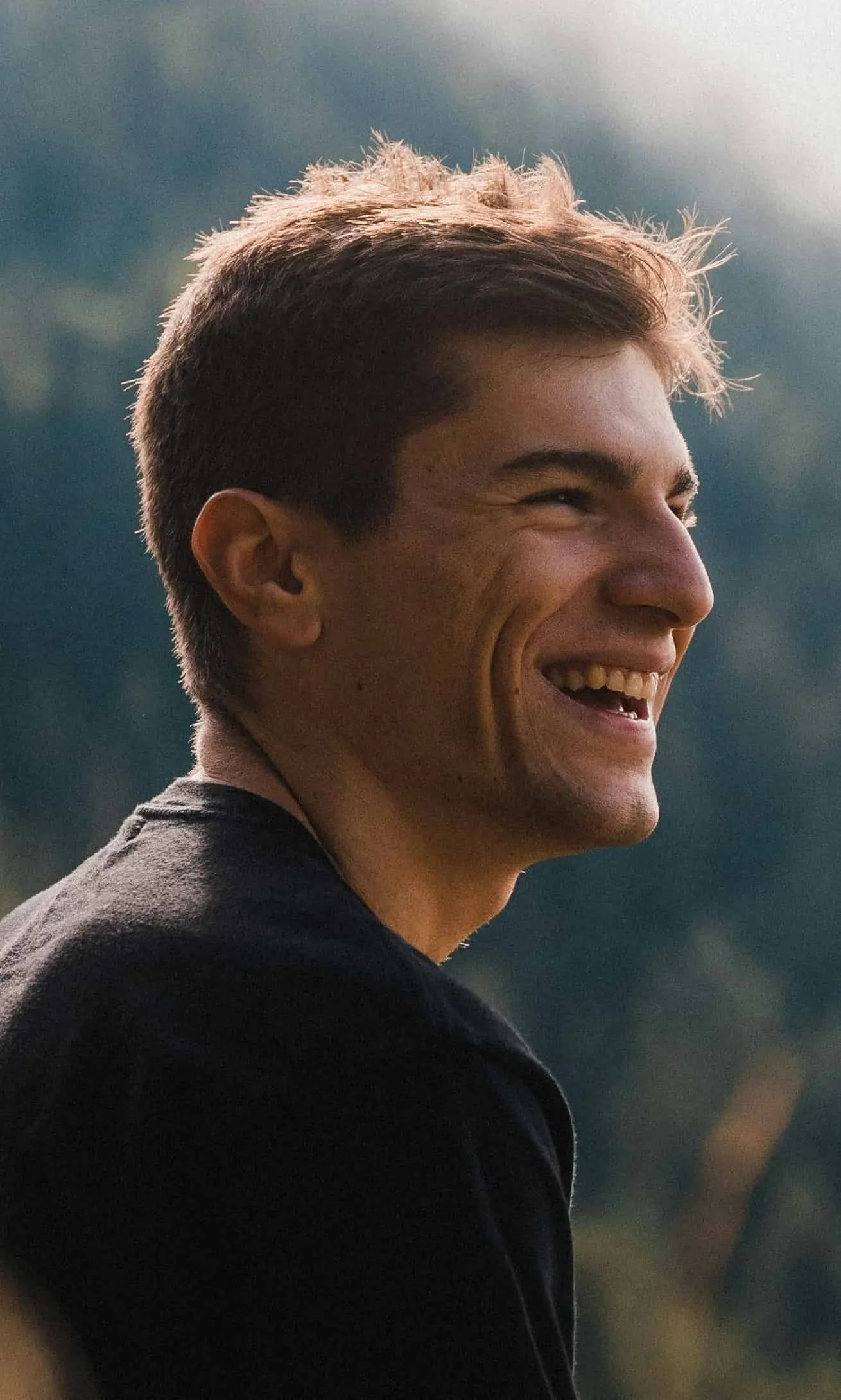 man sitting on rock and laughing