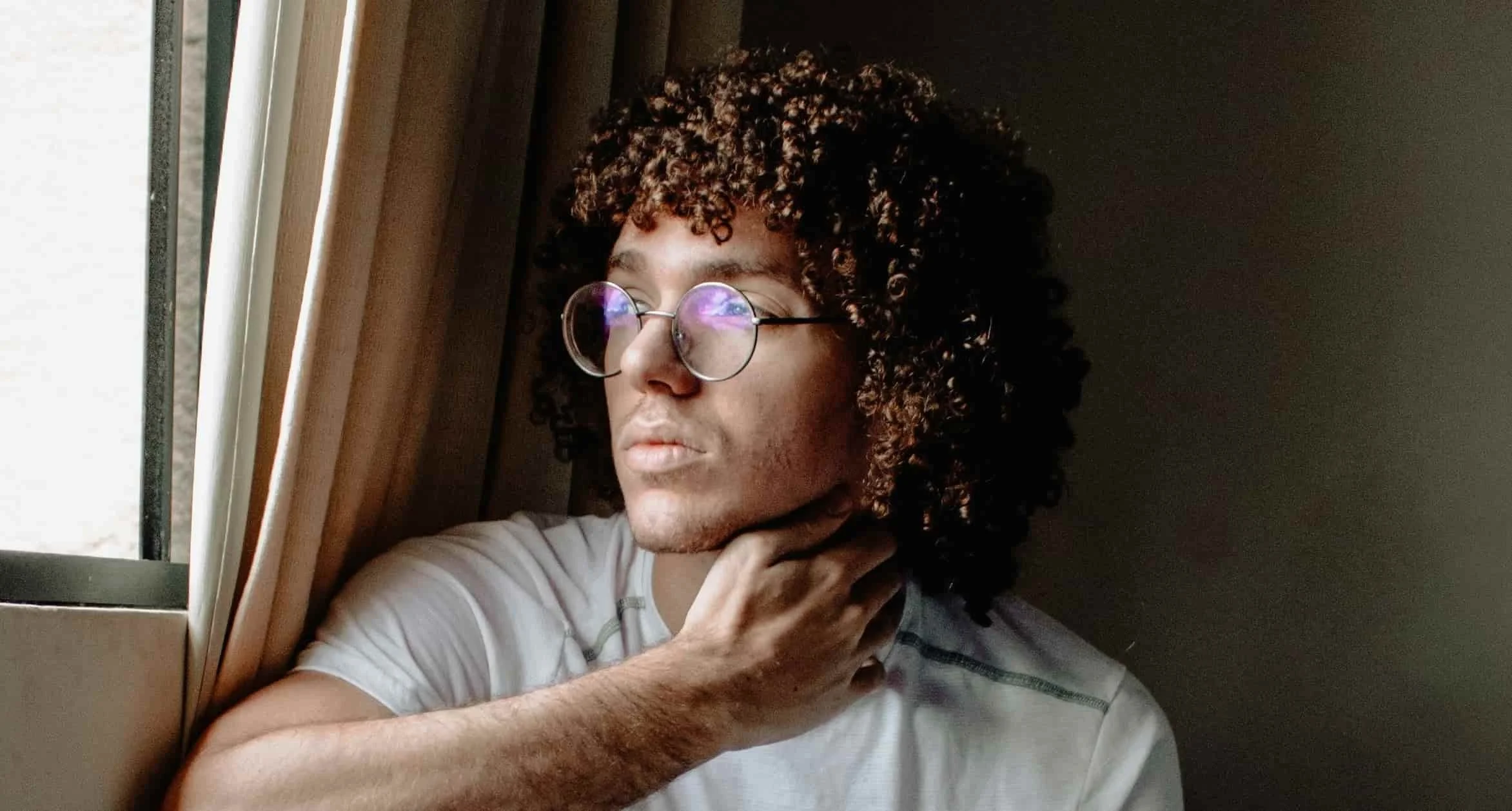 teen sitting by window
