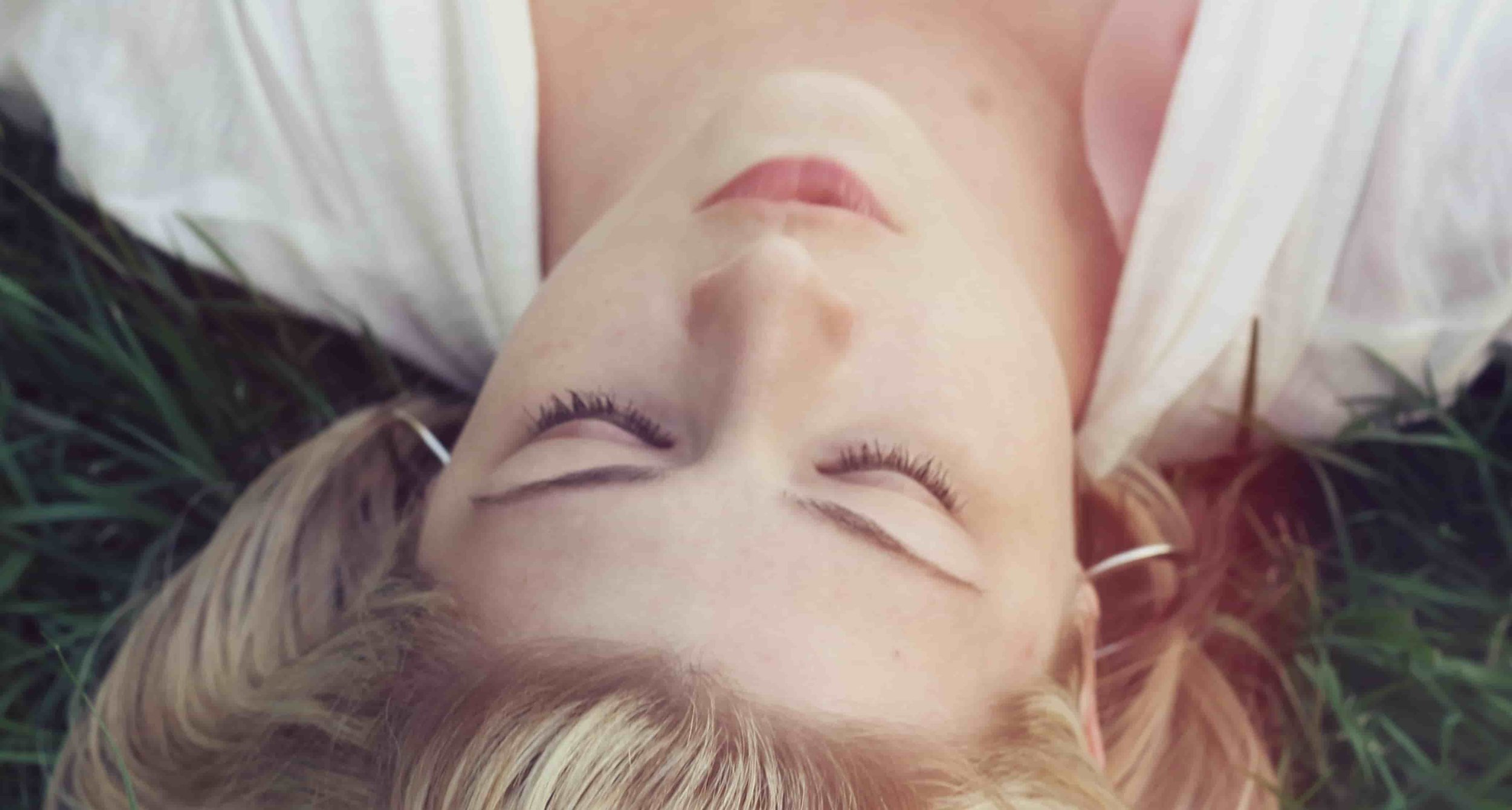 girl laying in grass with eyes closed