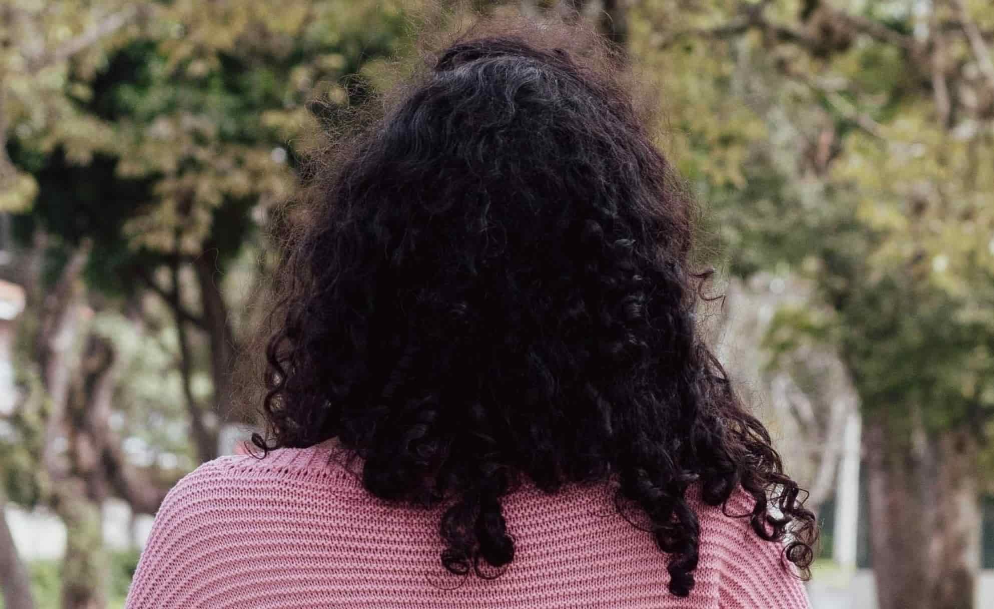 back of woman sitting on bench