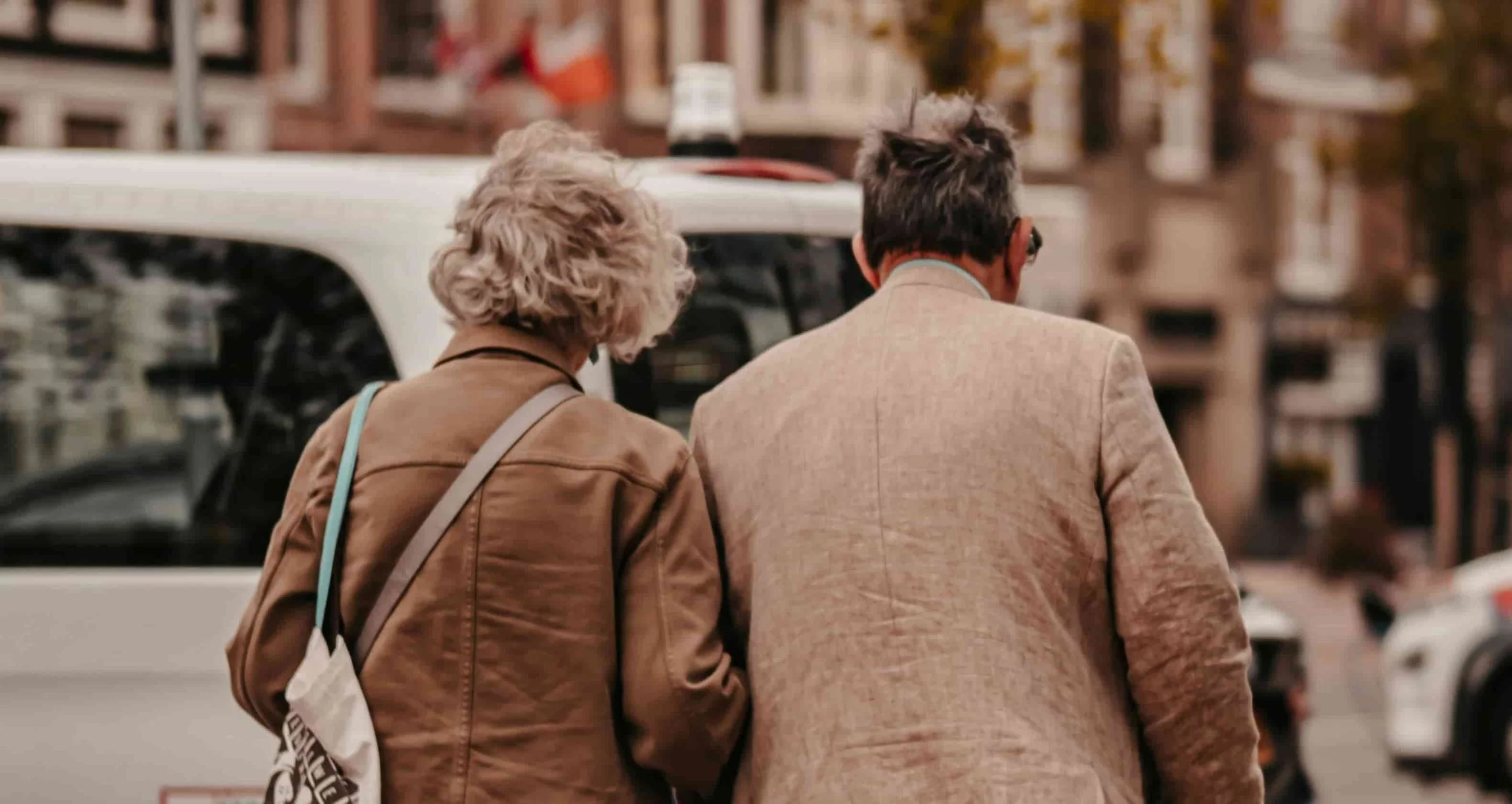 back of couple who are walking on street together