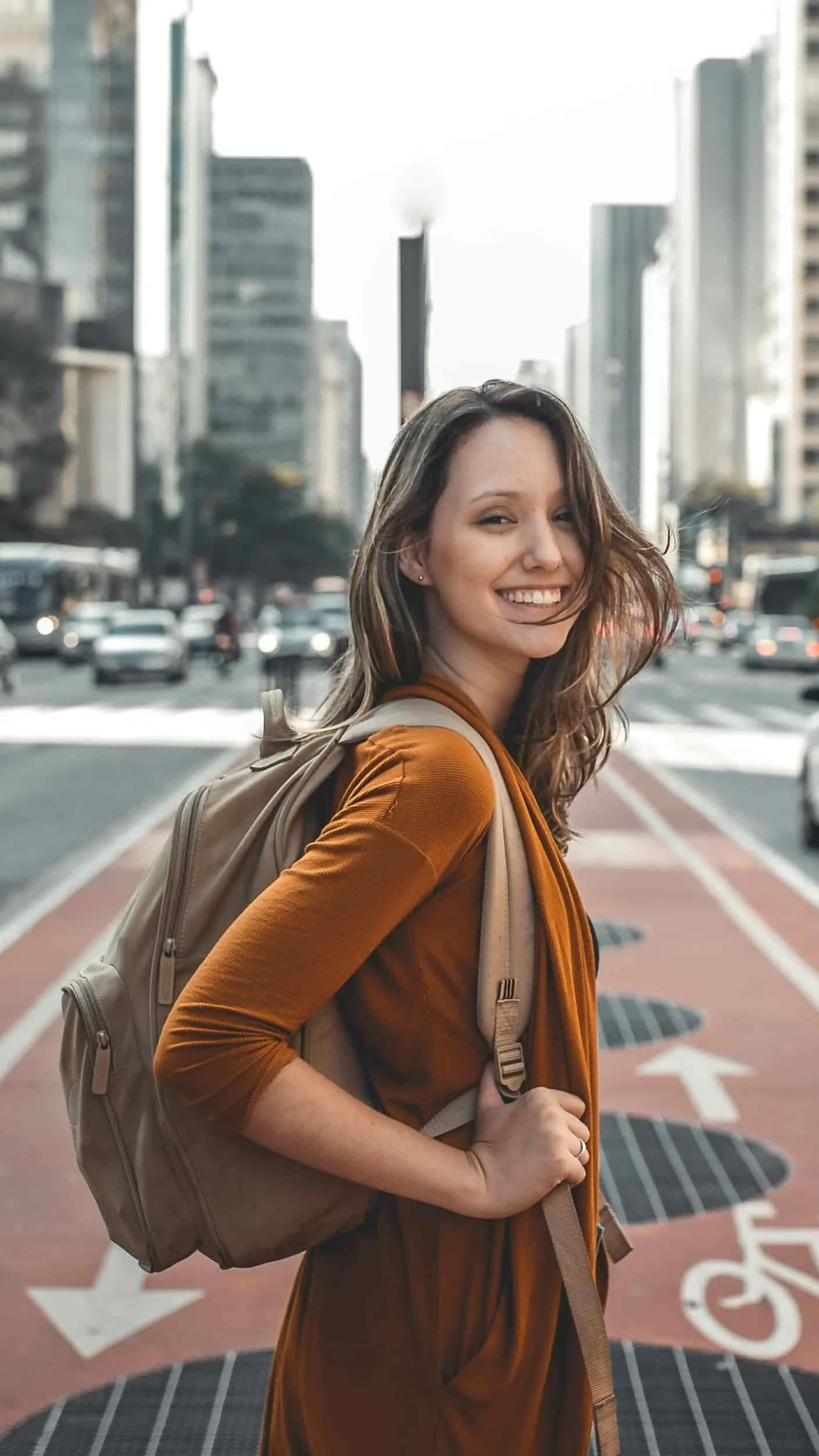 lady turning around and smiling while crossing the street