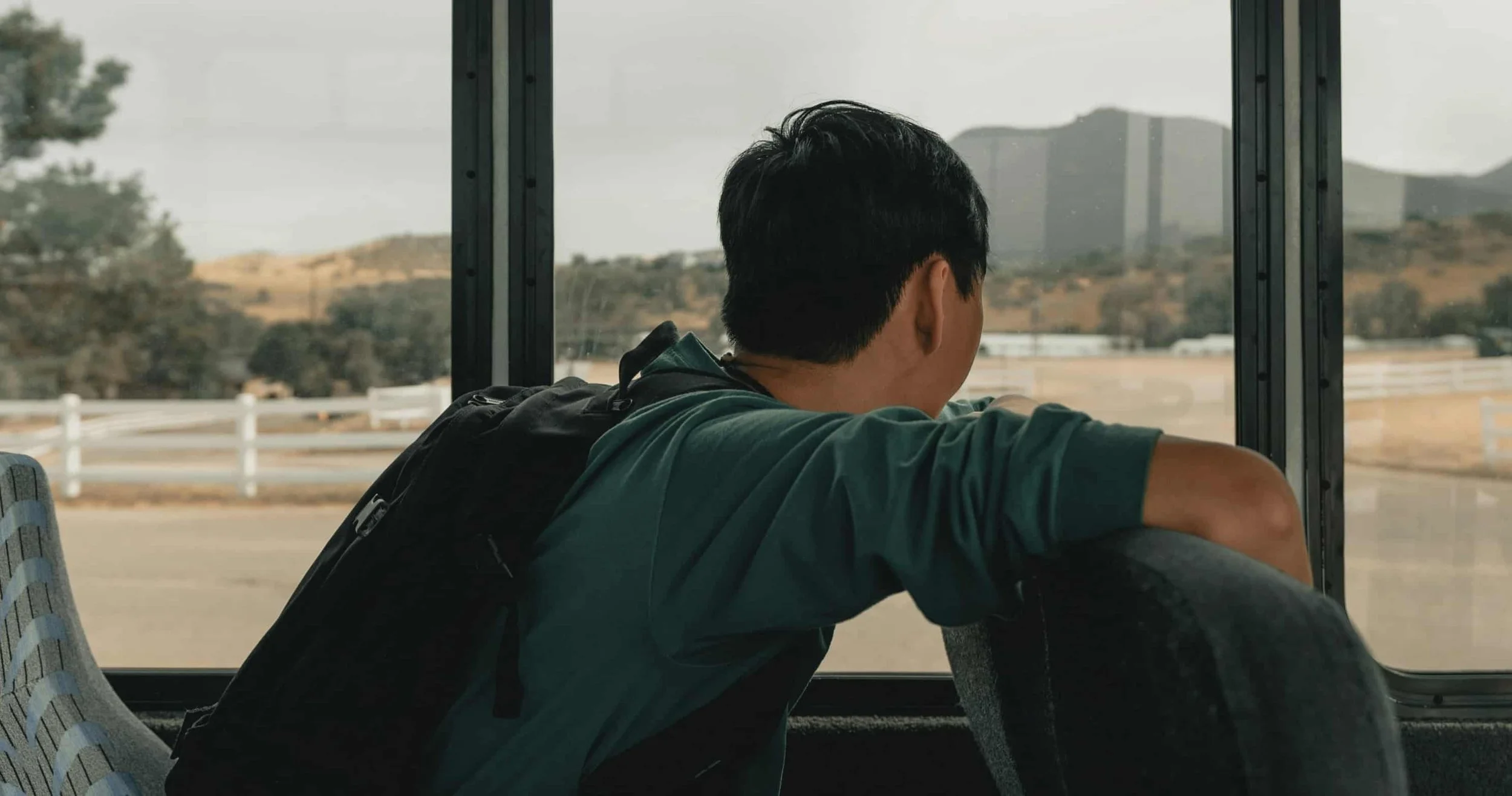 boy sitting in bus looking out the window