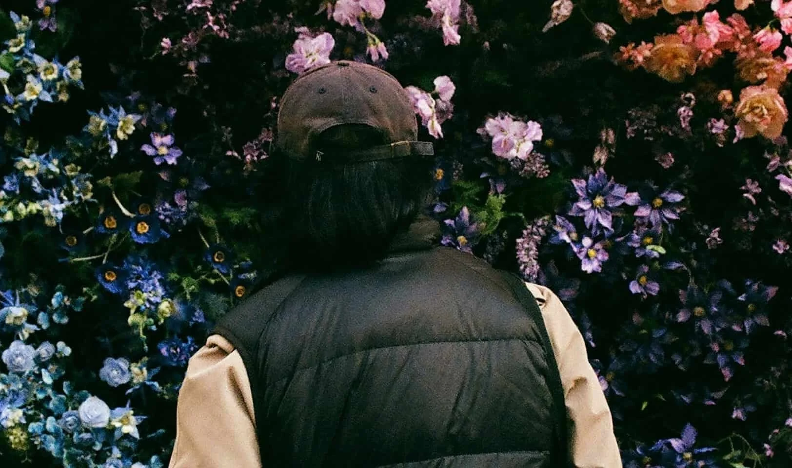 person looking at wall of colorful flowers