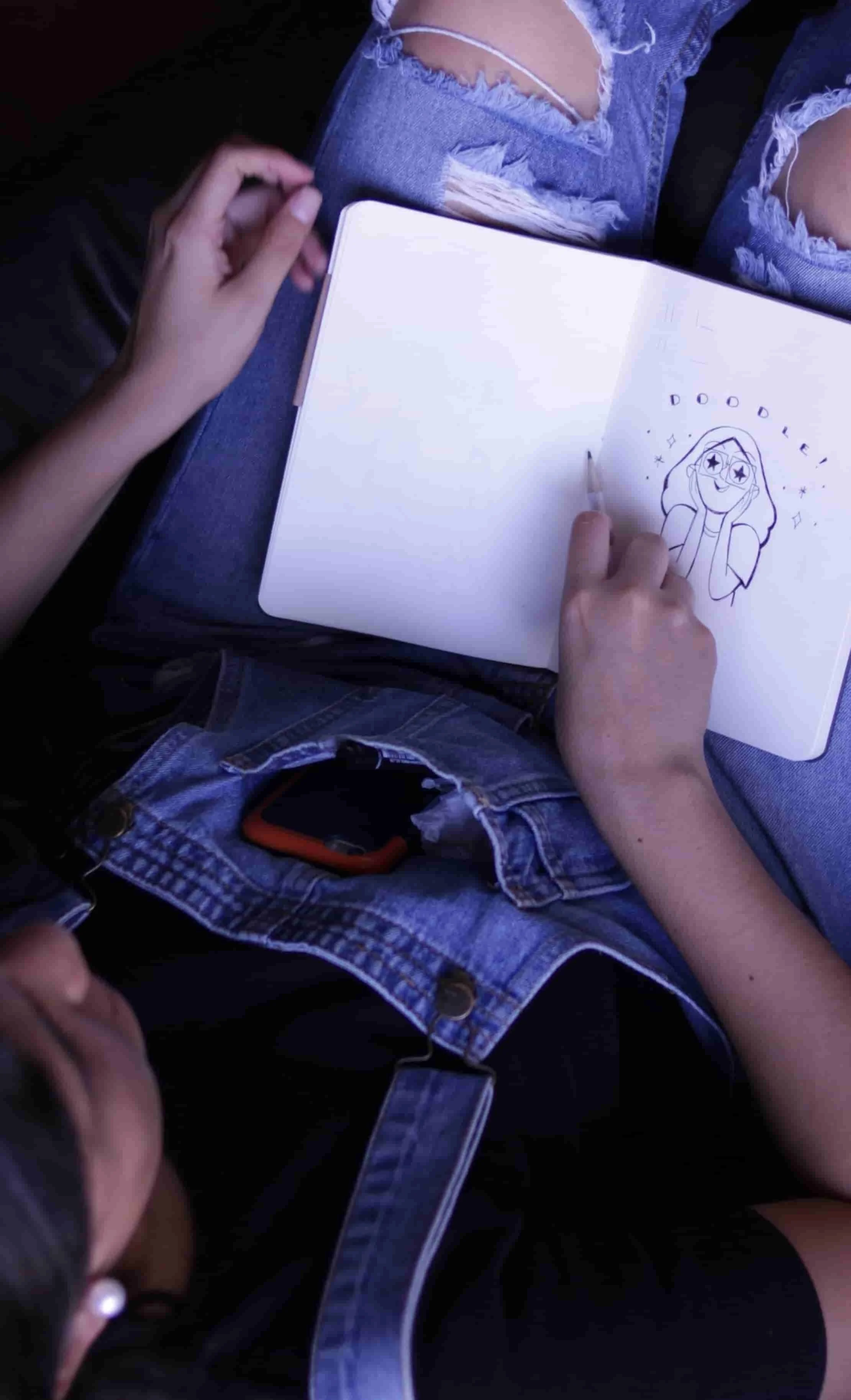 little girl drawing in notebook