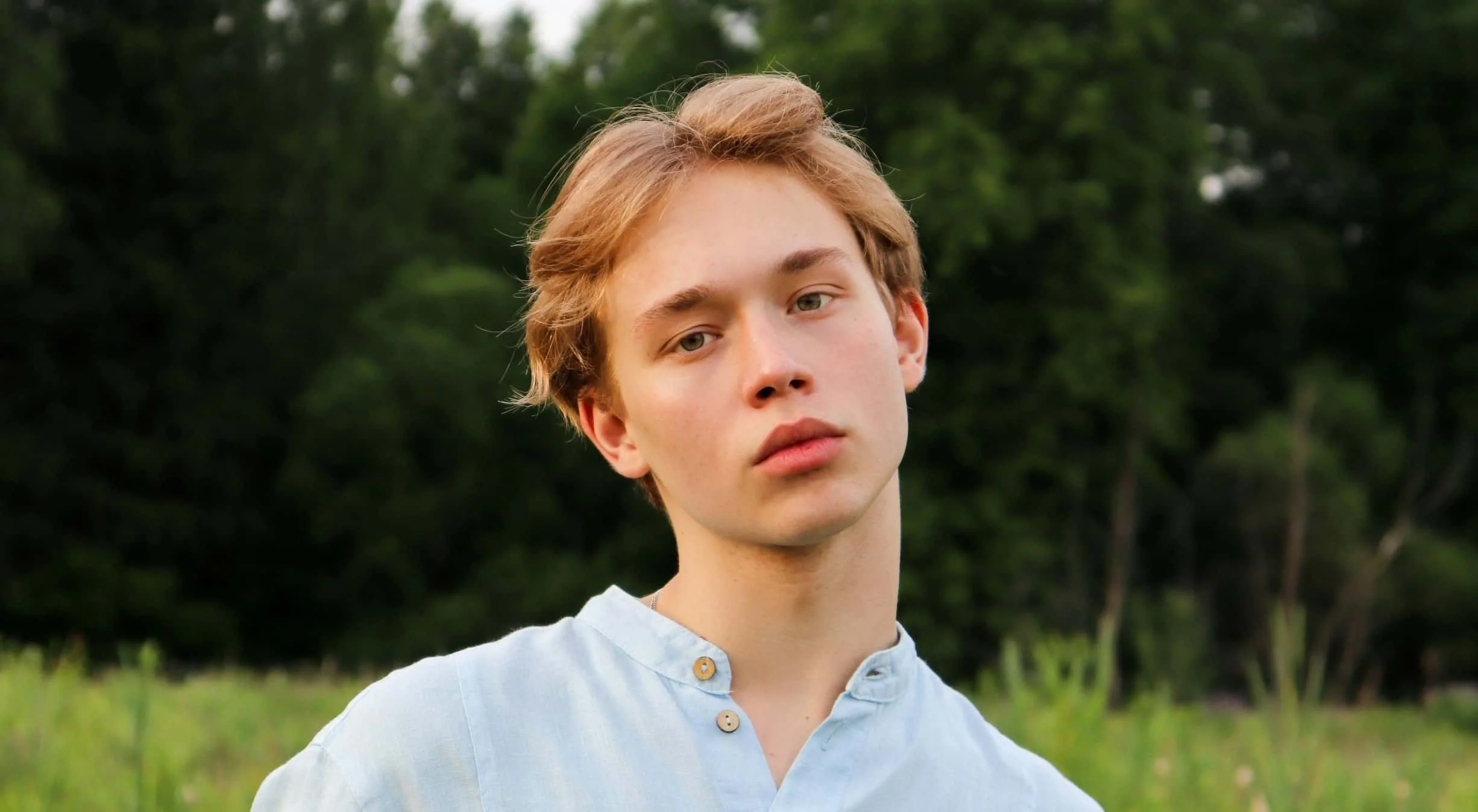 teen boy standing in field