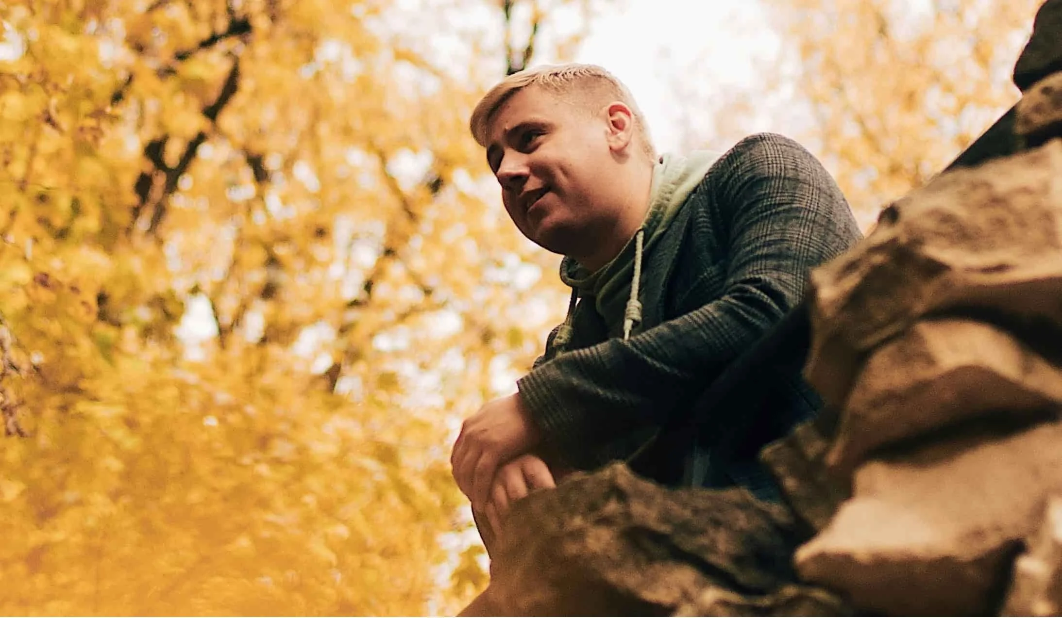 man leaning on rocks in the forest