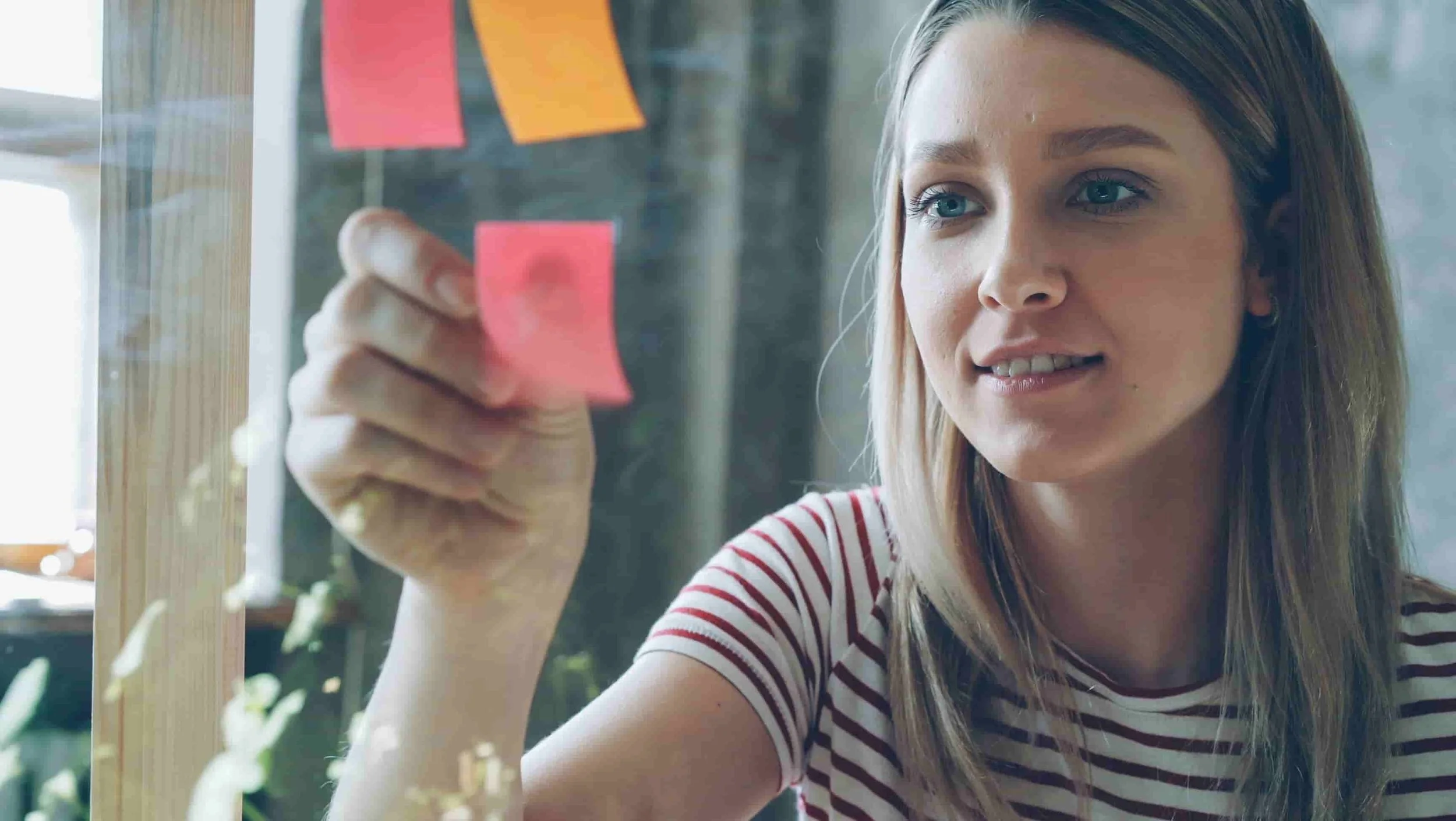 female university student using sticky notes to organize schoolwork