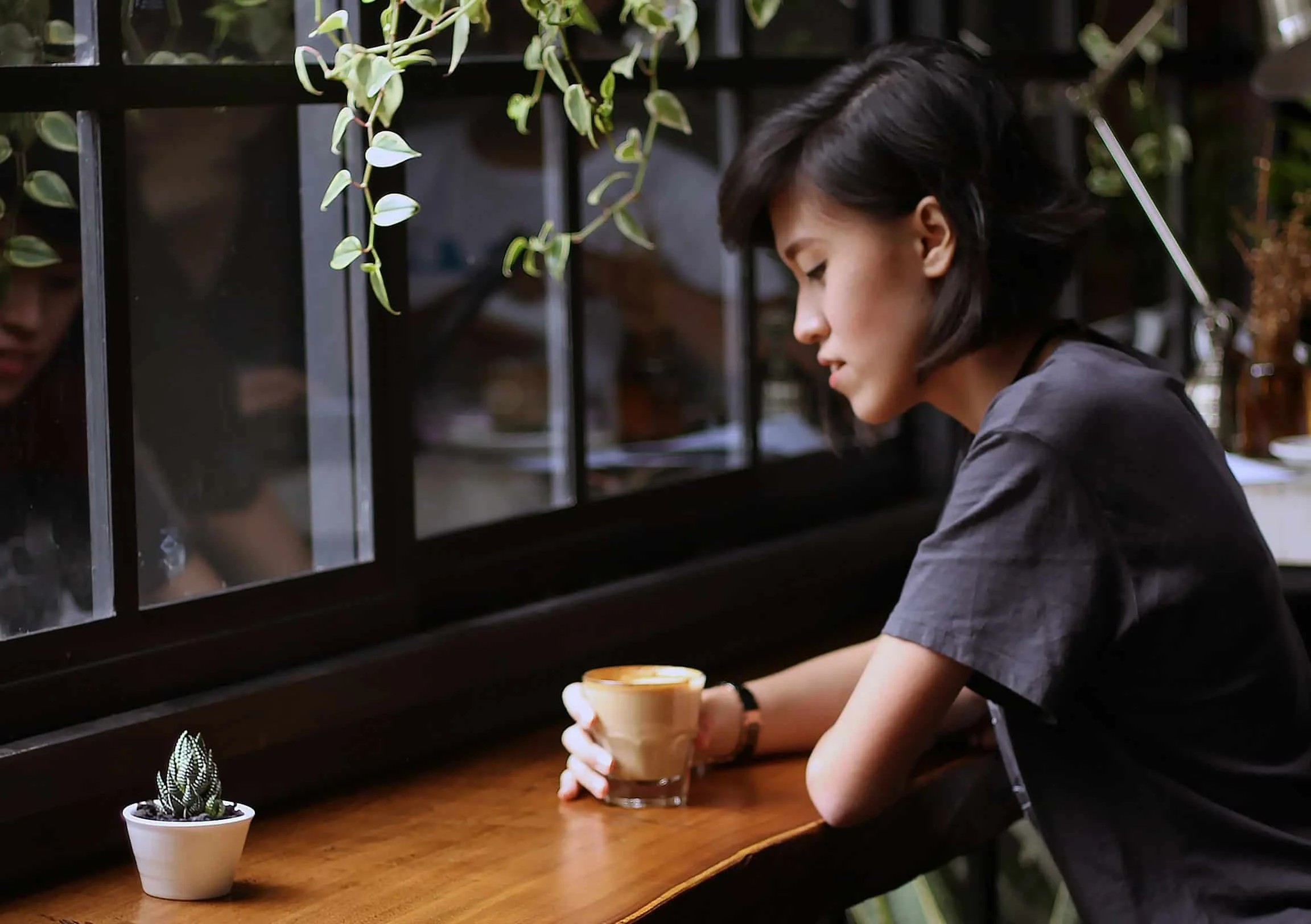 woman sitting in cafe drinking coffee