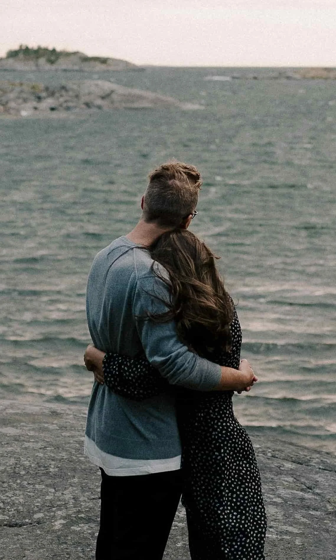 couples standing on rocks by river and hugging each other