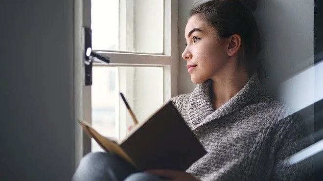 woman looking out the window coping with anxiety