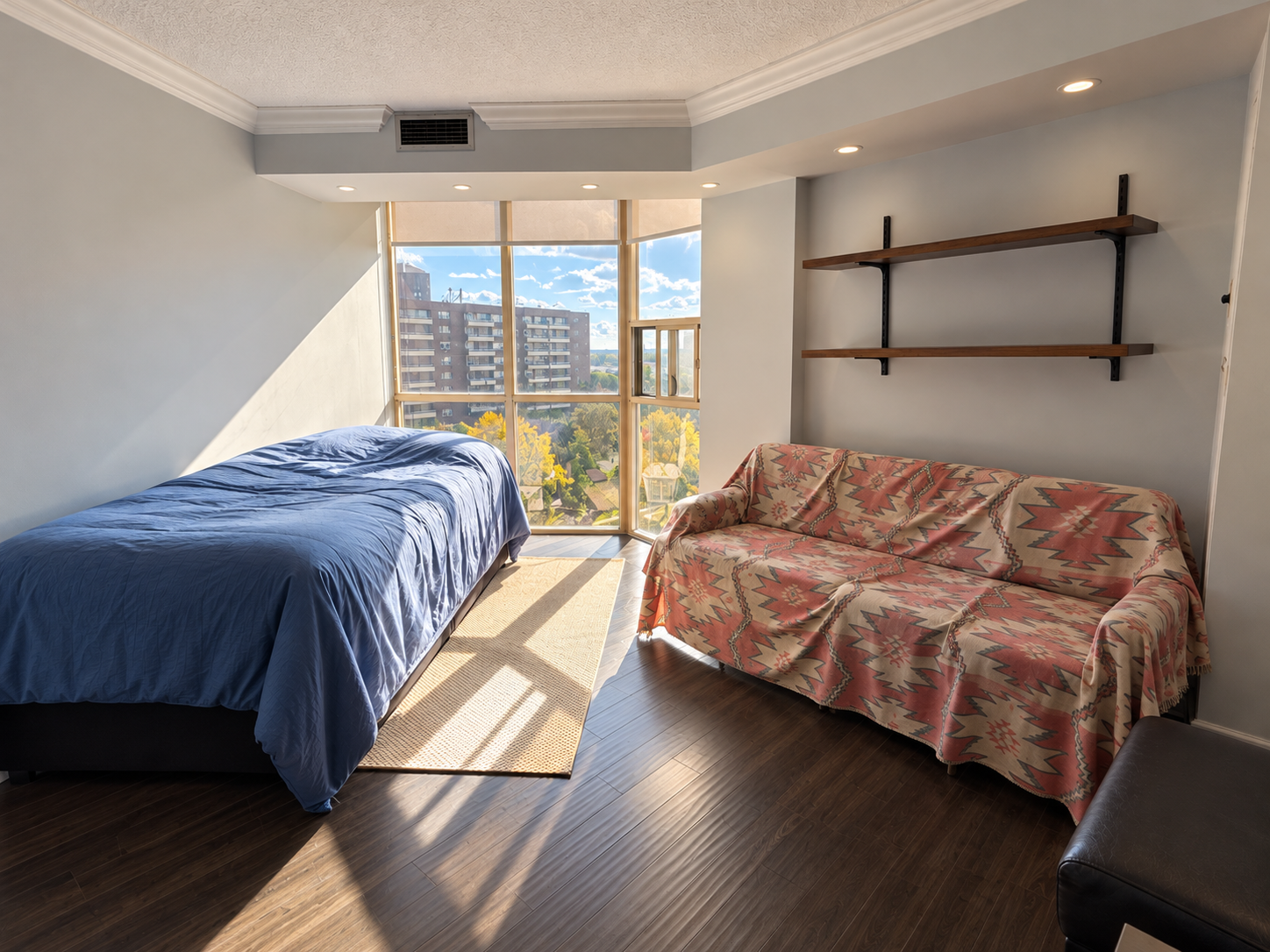 Sunlit Apartment Bedroom with Patterned Sofa Cover.png