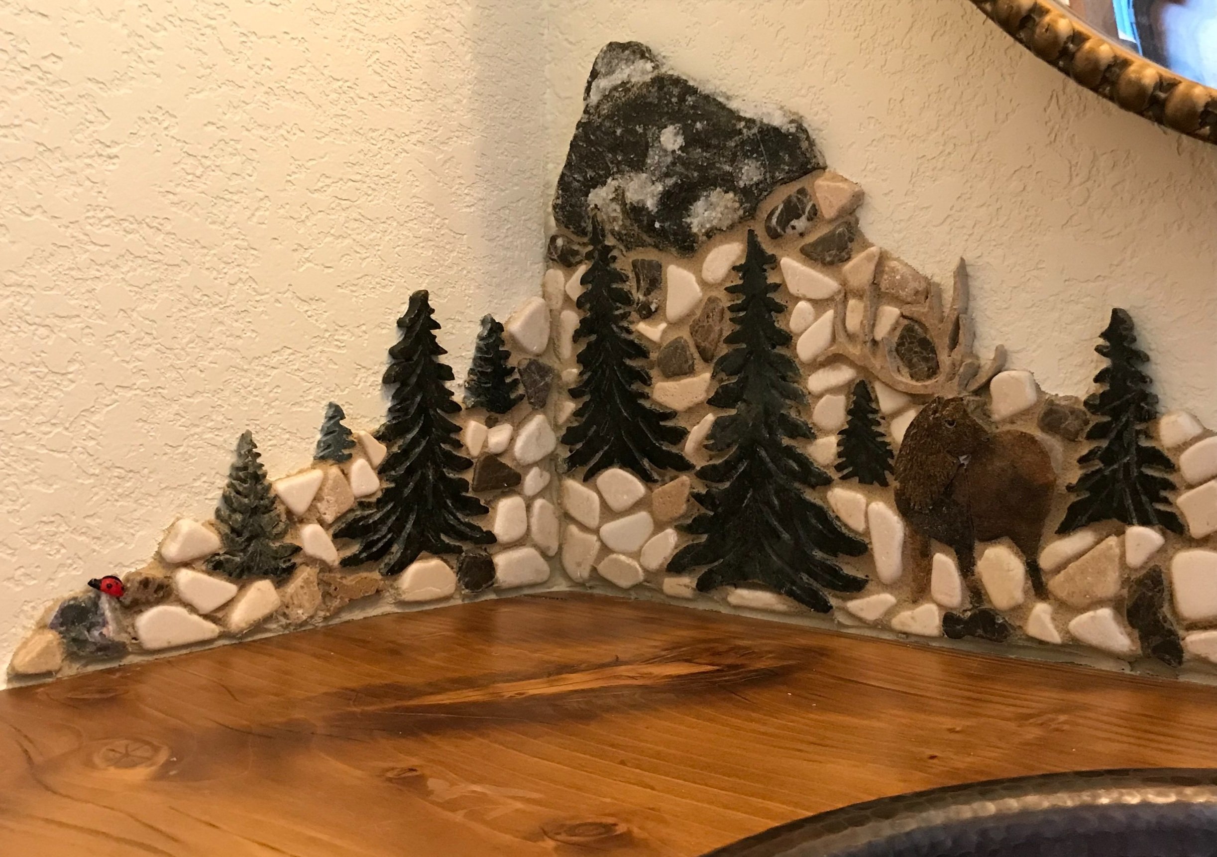 Close up of left side shows my lady bug signature and a little chunk of amethyst to add some good vibes (protection and peace).
I used a flexible shaft Dremel to detail the pine trees, and added some white marble for snow; for cleansing, healing and