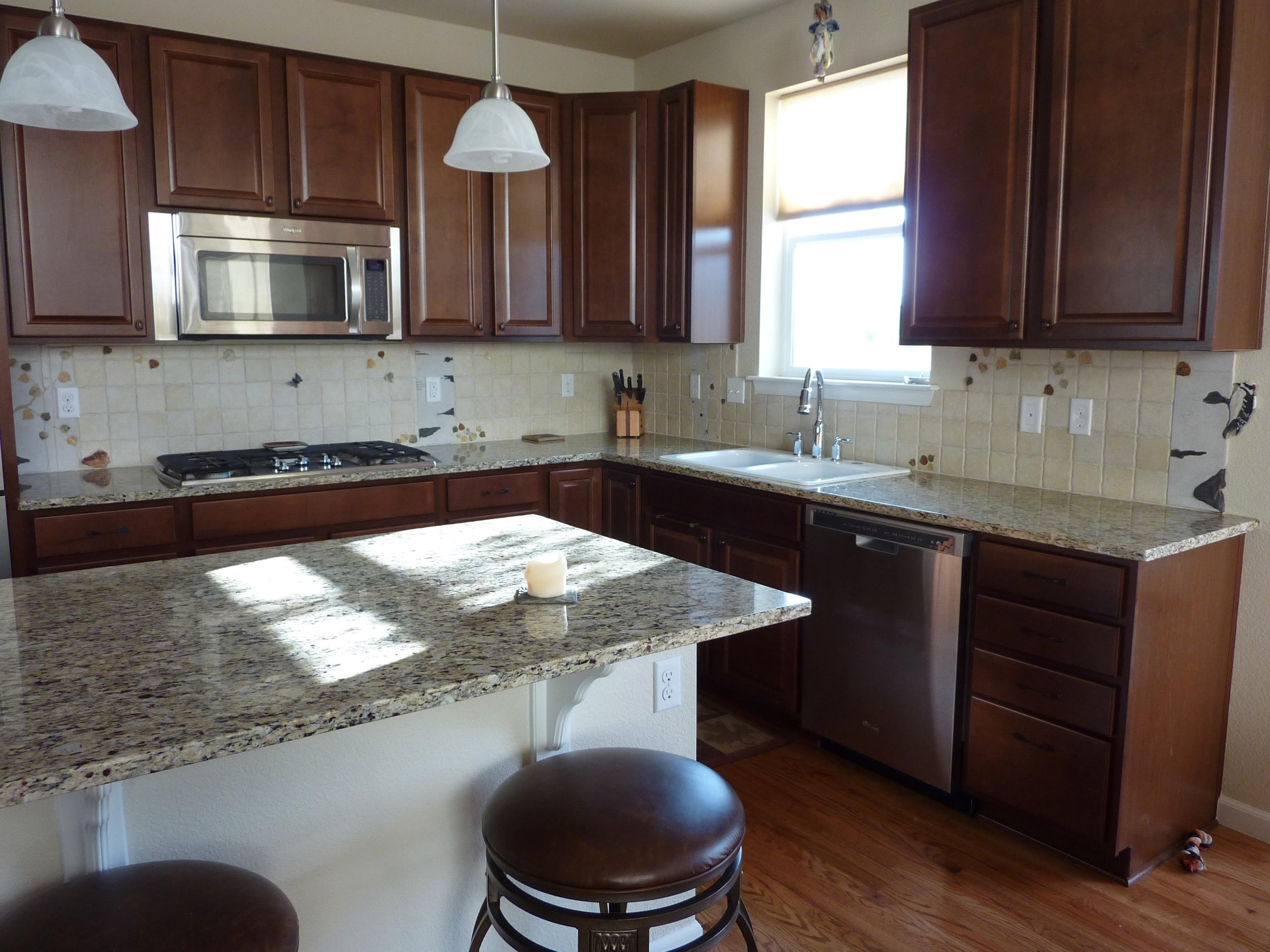 Aspen trunks are made from porcelain tile and black slate. The aspen leaves cut from rare rust, green and honey onyx, soothe the stress of everyday life, bringing grounding and harmony energies to this kitchen.
A glass butterfly sits above the cook