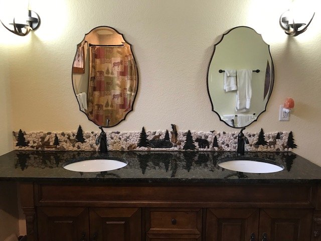 8" x 86"
With over 400 pieces, this backsplash was designed as a unique work of art to match the stone accent installed in the shower and the shower curtain you can see in the left mirror.
It tells a story of a day in the forest with mama bear and t