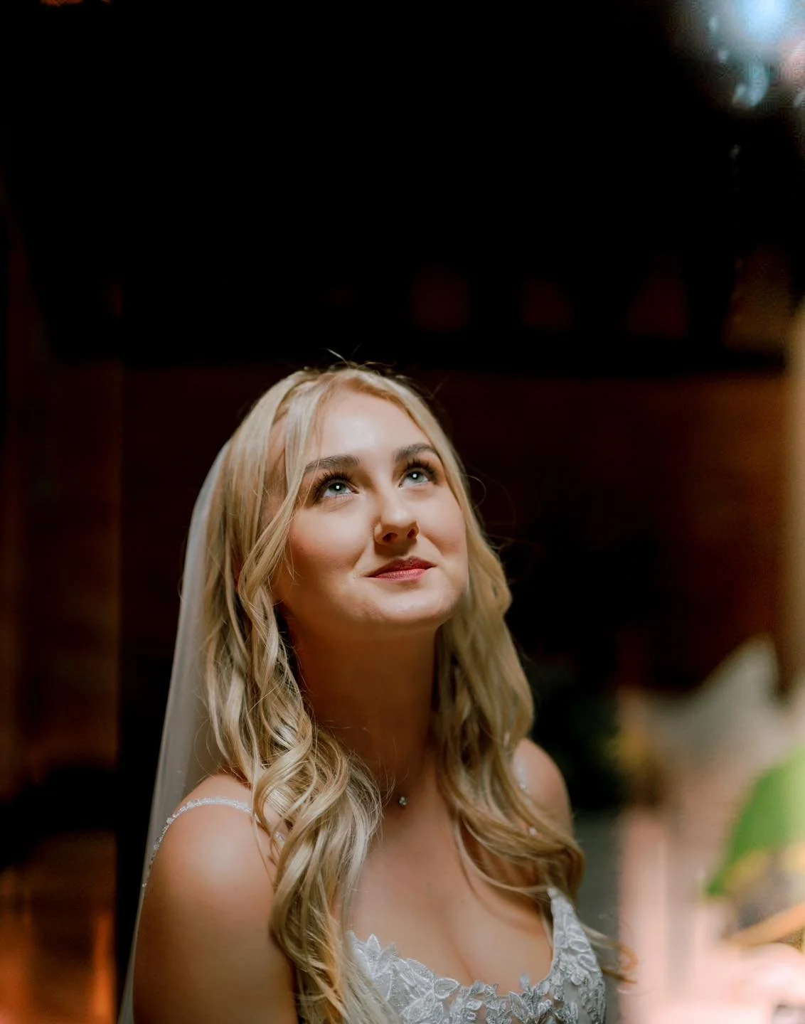 bride smiling and looking up into an out of shot window on her wedding day. ollerton pumphng house wedding