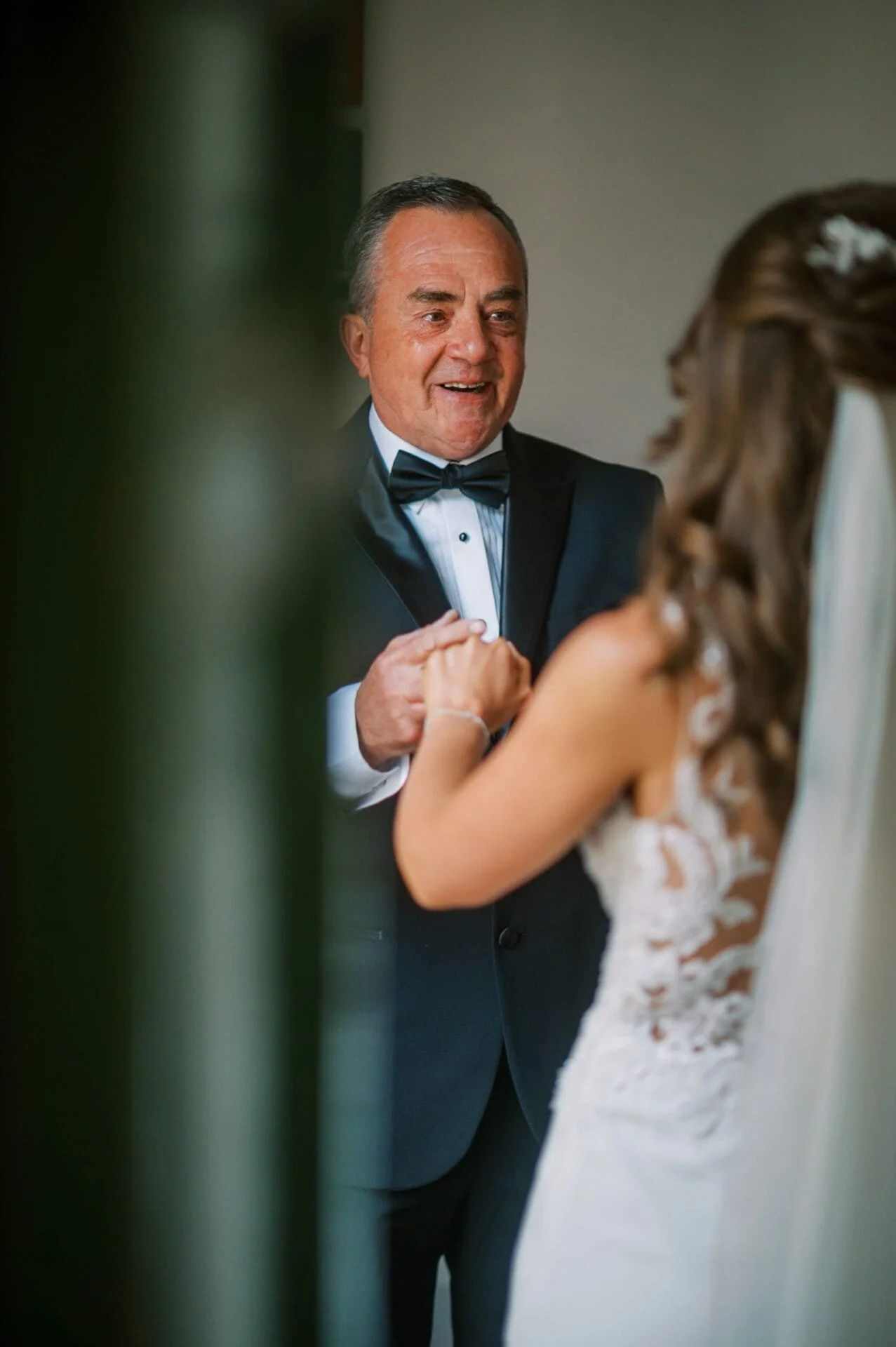 emotionla father holding hands of his bride daughter on her wedding day