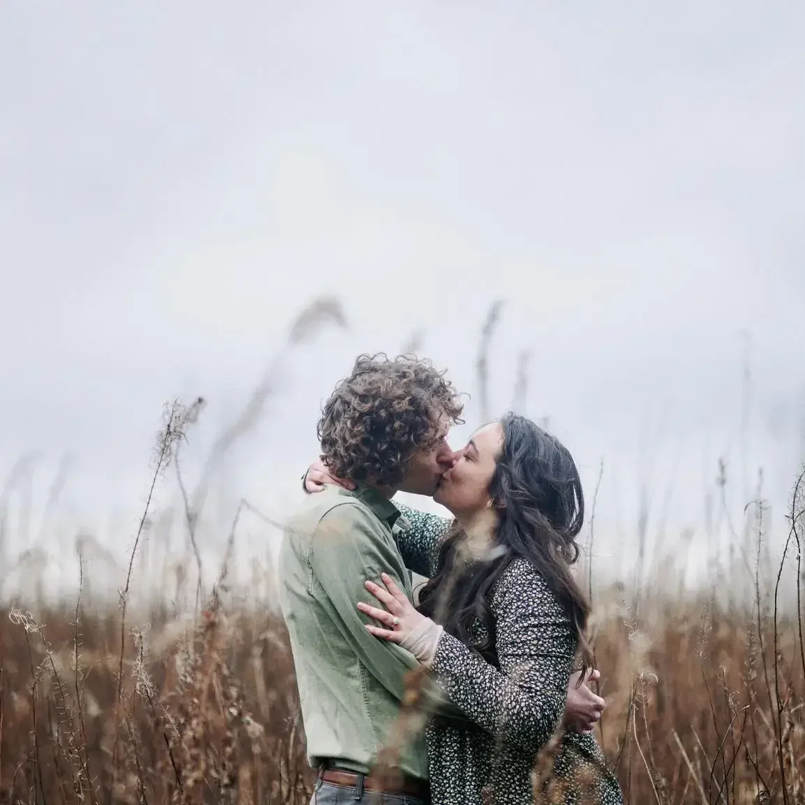 couple kissing on a overcast cloudy day in the Yorkshire wilderness on their pre-wedding photoshoot
