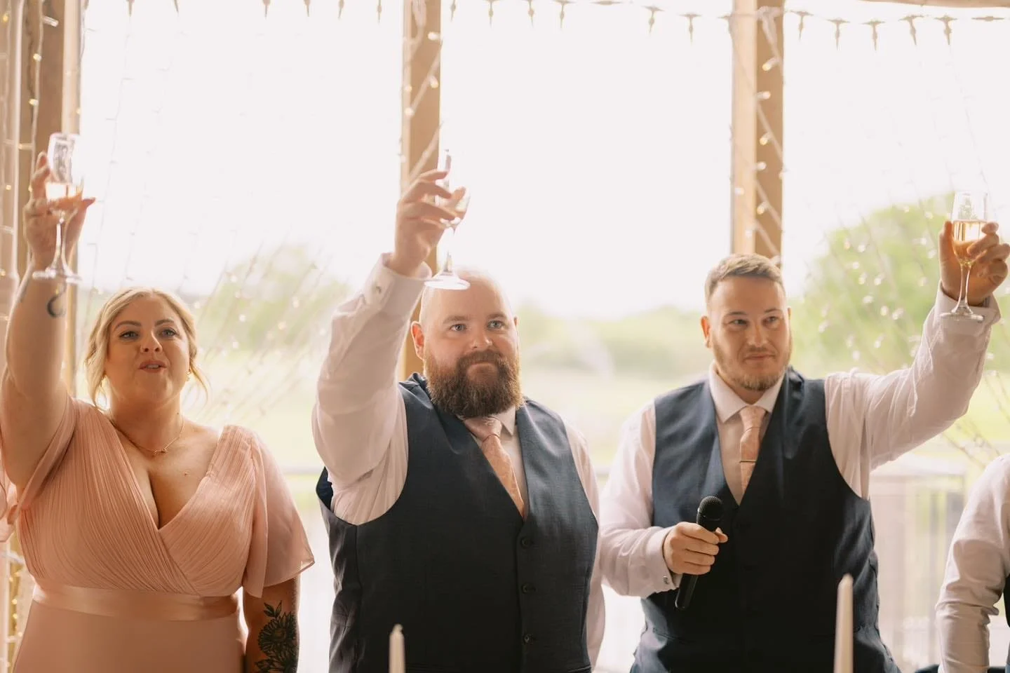 3 people rasing glasses and cheers at an LGBTQ+ wedding at Sandburn Hall York
