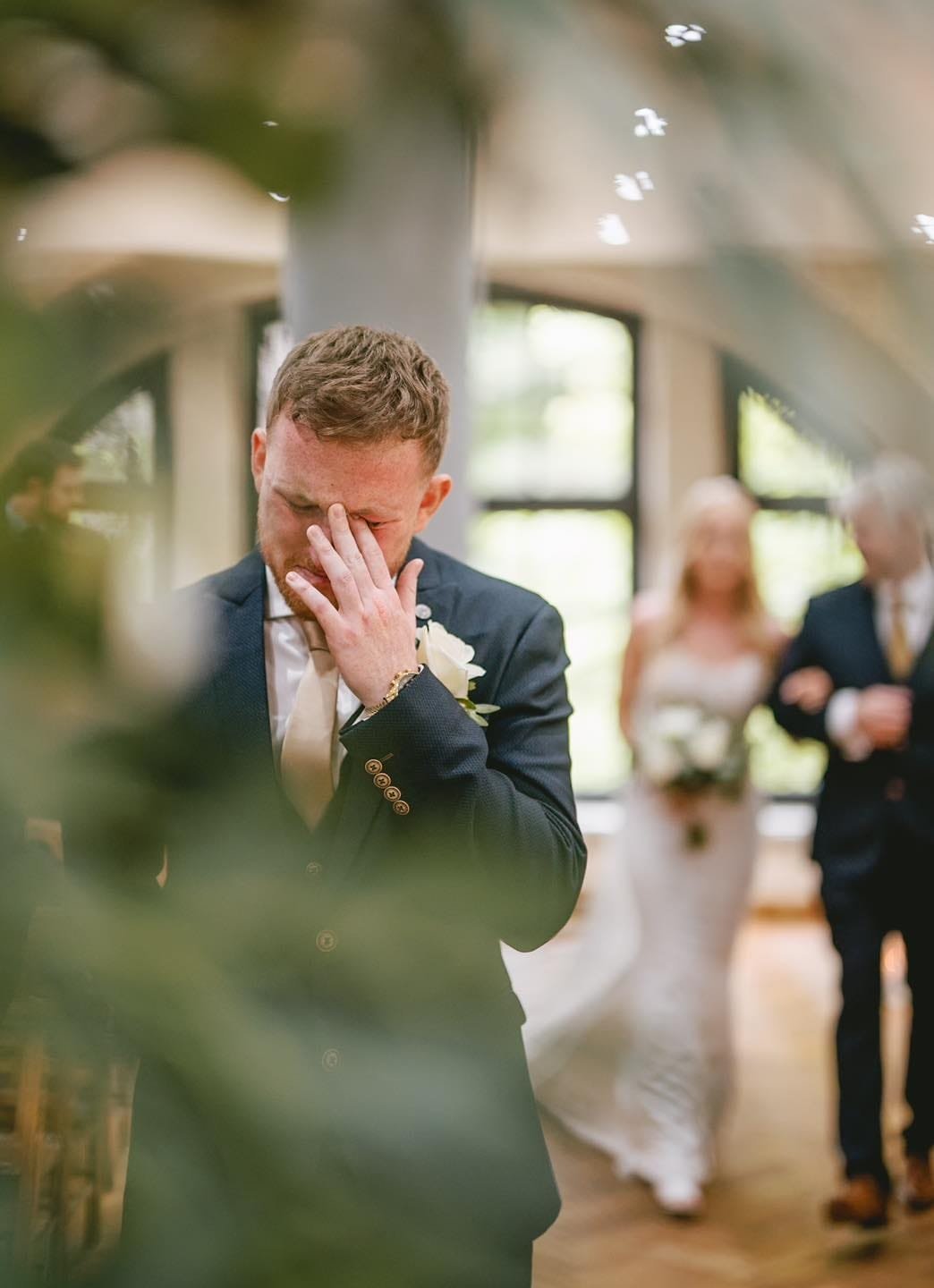 groom crying and wiping his eye at ollerton pumping house as his bride walks down the aisle