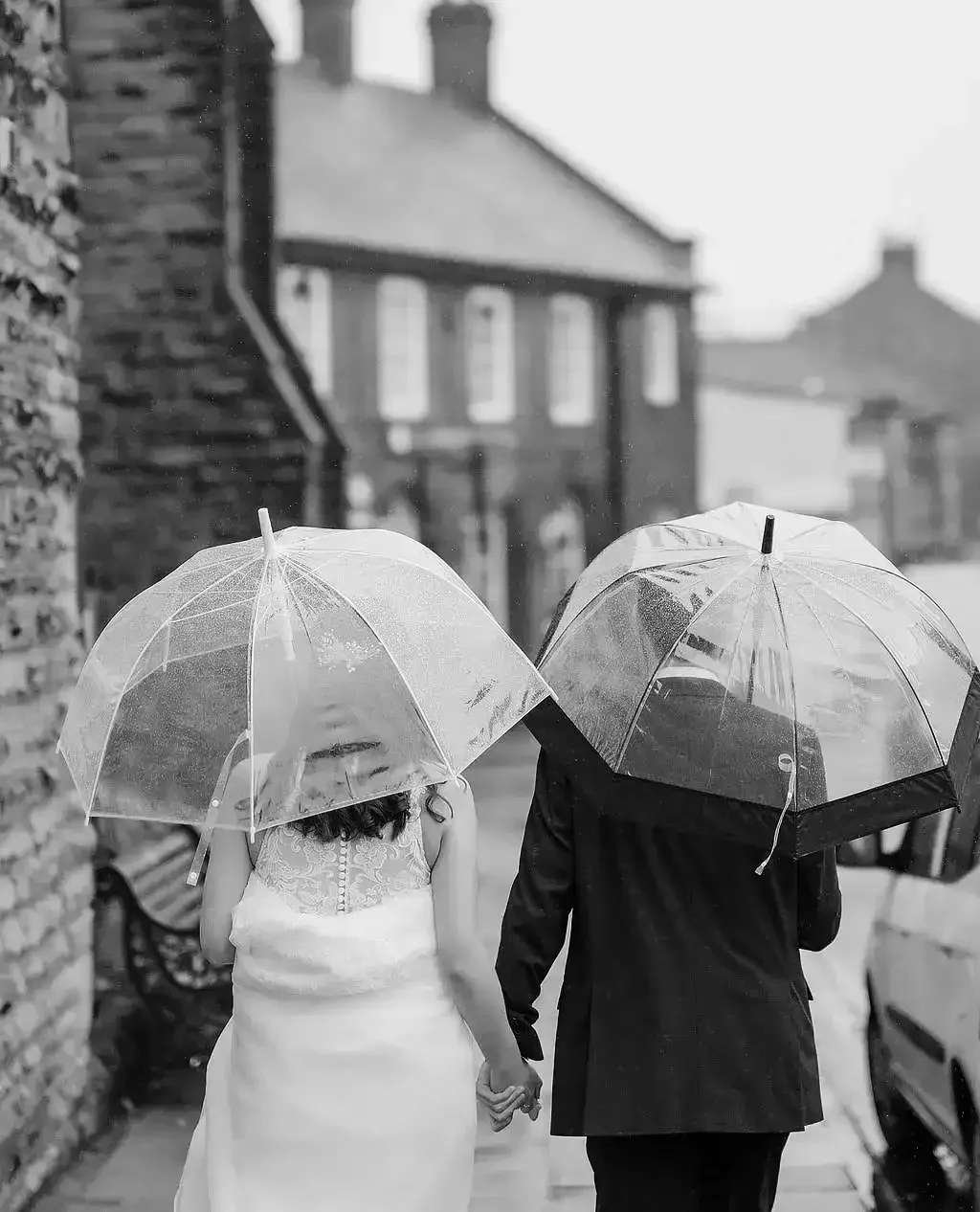 Filey brigg wedding  Eleopment photographer bride and groom walking in the rain with umbrellas in teh rain002.webp