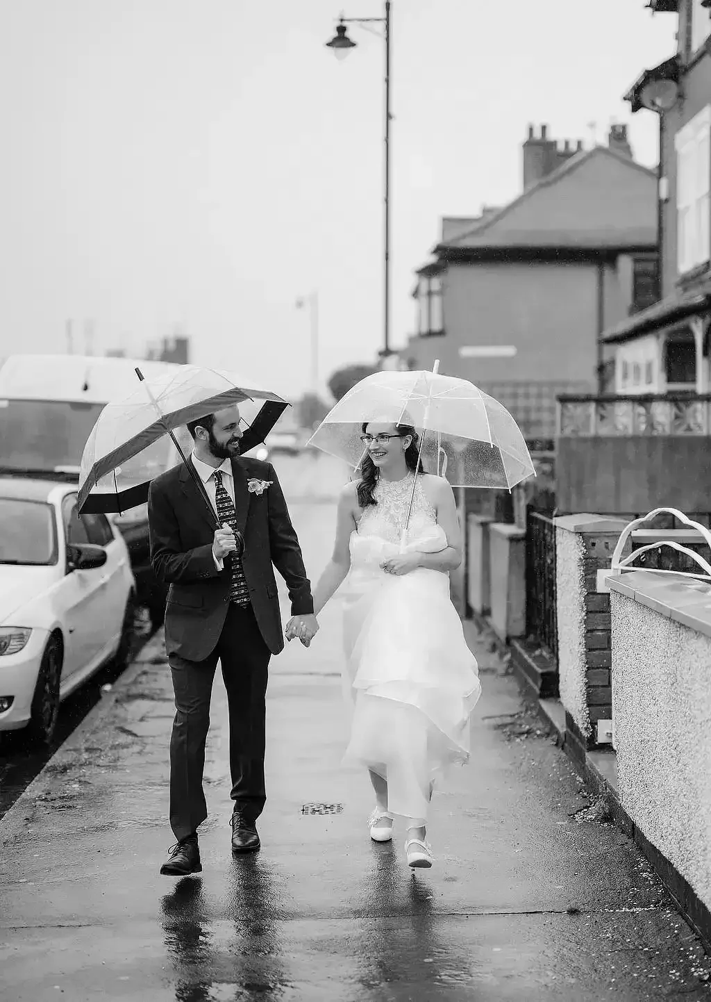 Filey brigg wedding  Eleopment photographer bride and groom walking in the rain with umbrellas in teh rain001.webp