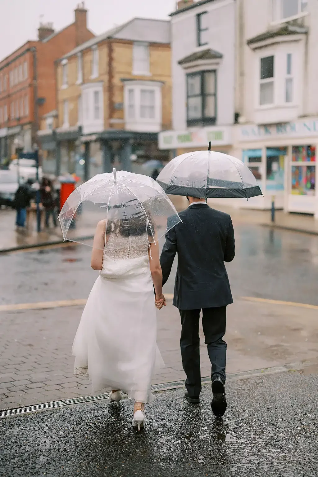 Filey brigg wedding  Eleopment photographer bride and groom with umbrellas in rain001.webp