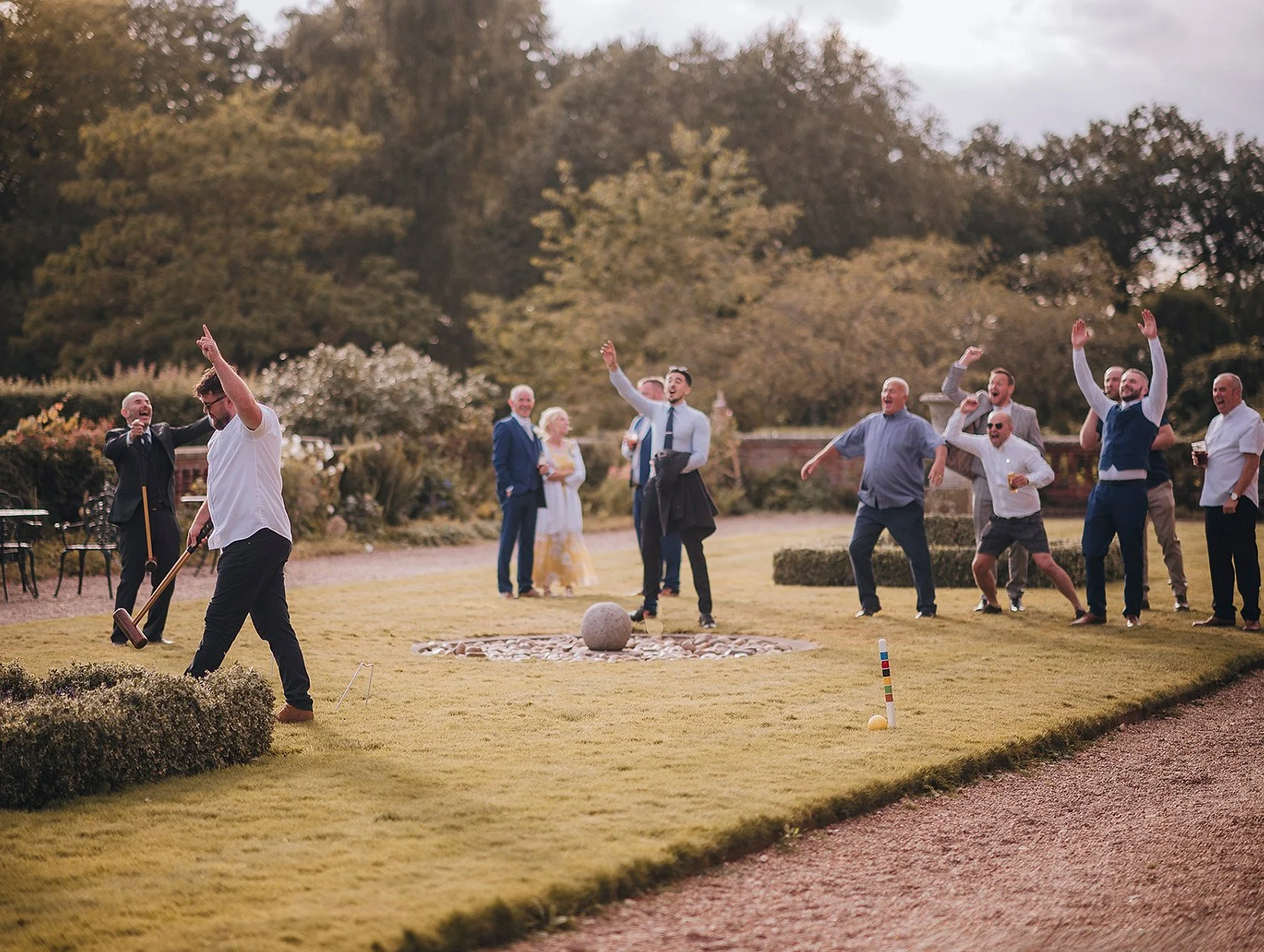 men celebrating playing garden games at hodsock priory wedding