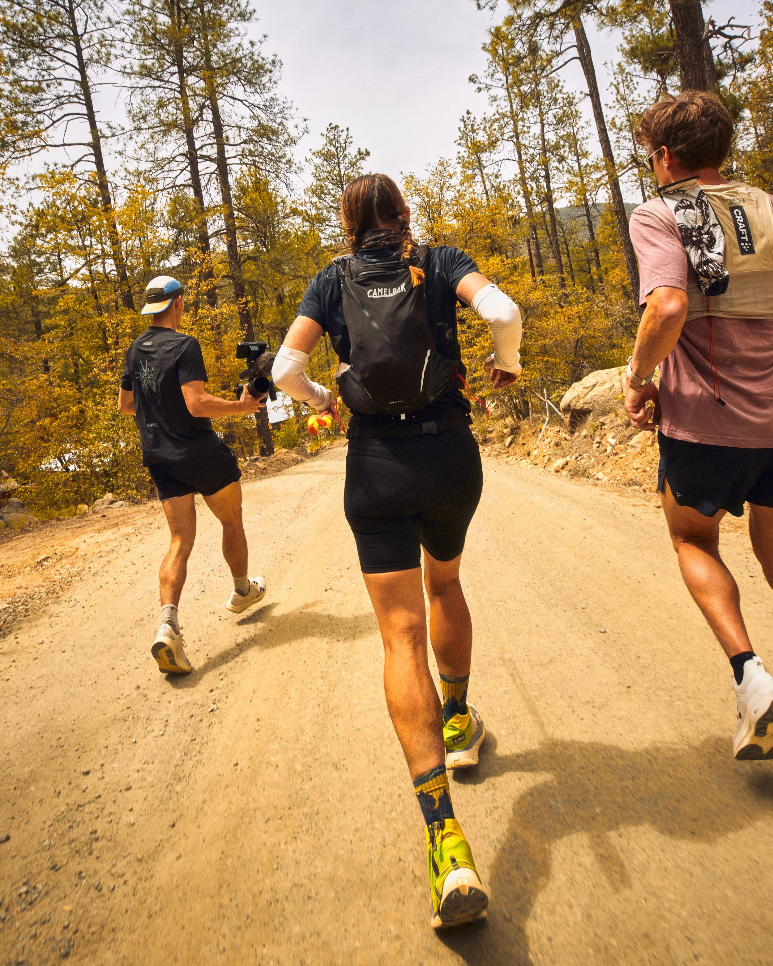 Group of runners in athletic clothing jogging on a dirt trail 