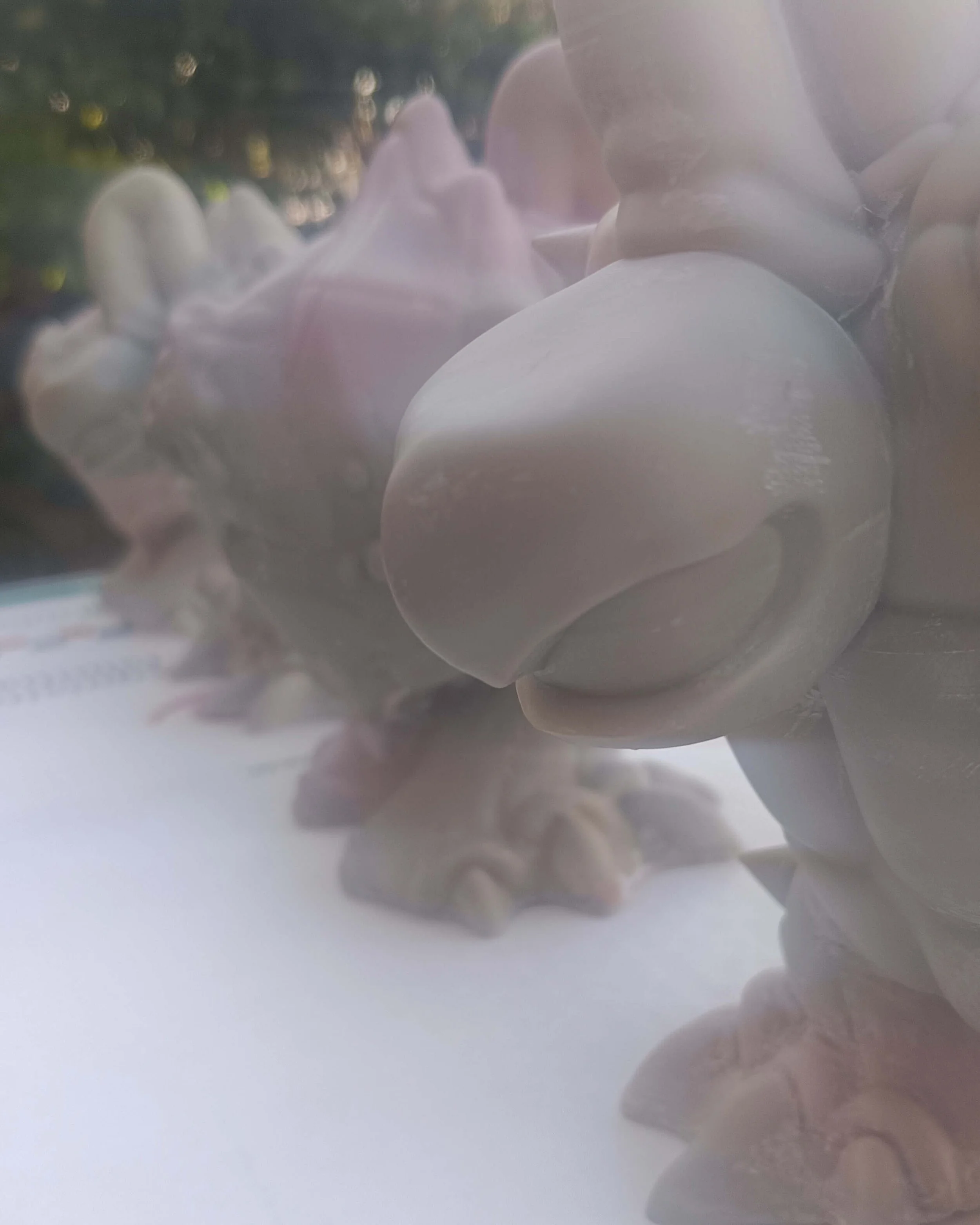 A row of resin cast art toy figures in a smooth grey finish, showing the detail of the lowbrow character design during the production phase.