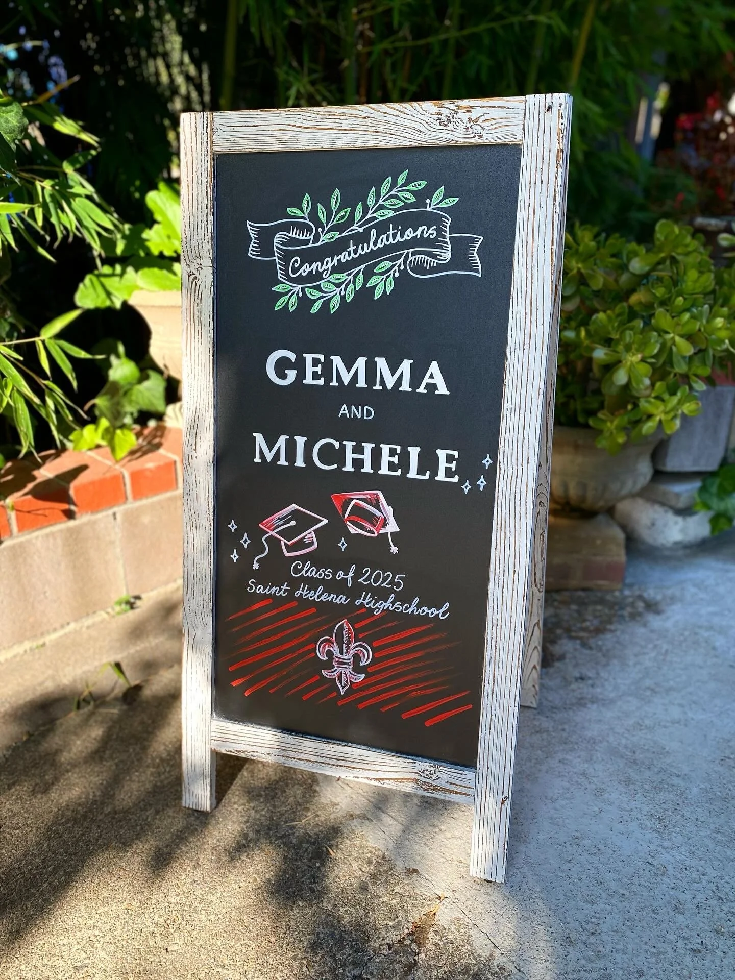 hand lettered high school graduation chalkboard. It reads Congratulations Gemma and Michele Class of 2025-Saint Helena Highschool