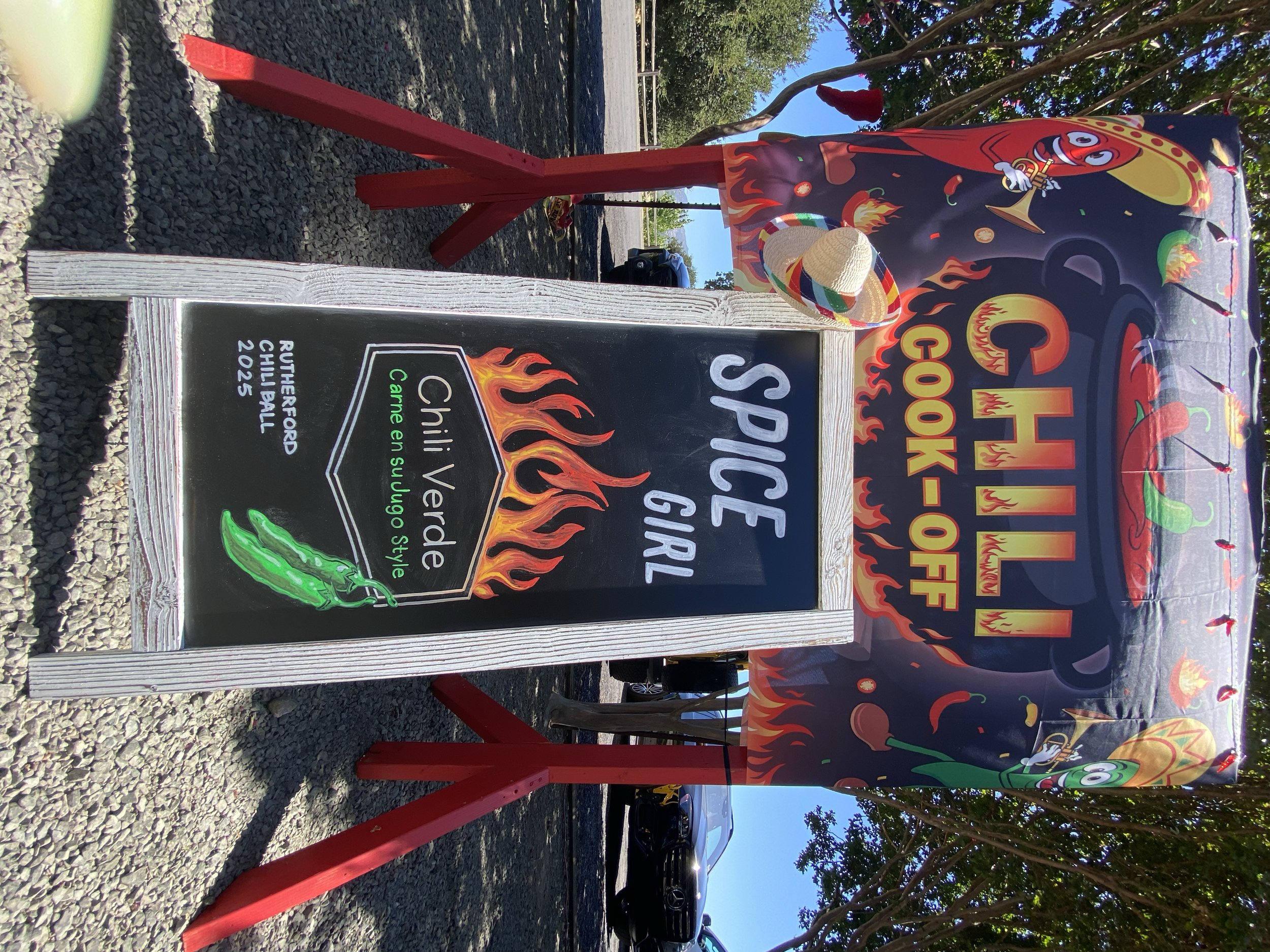 hand lettered chalkboard sign with hand illustrated flames and green chilis-It reads-Spice Girls, Chili Verde con sugo-Rutherford Dust Society Chili Ball 2025