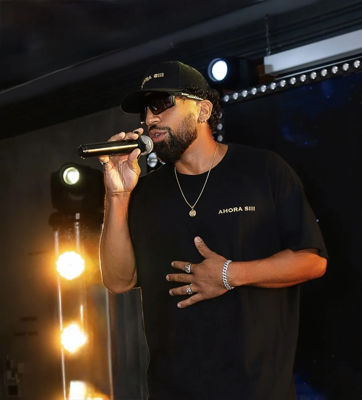 Nandy Versátil singing live in an AHORA SIII cap and shirt