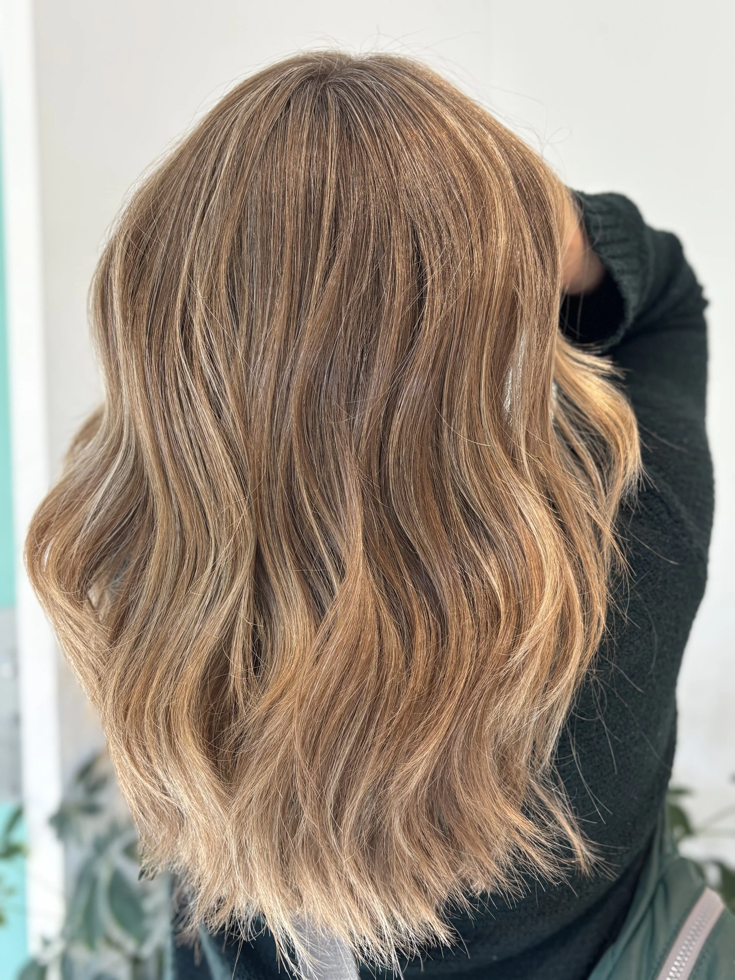 Close-up of a woman with medium-length, wavy, light brown hair.