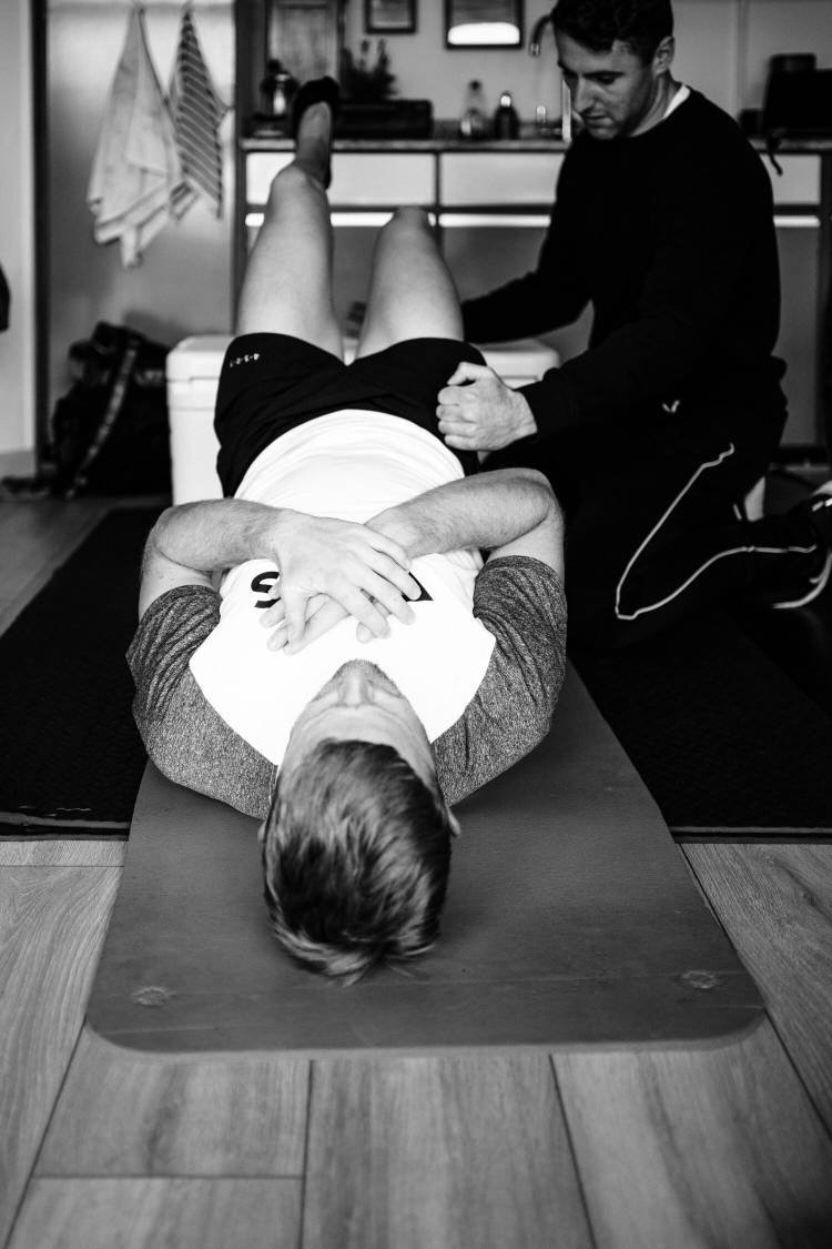 RÁS - Male athlete receiving physiotherapy whilst lying down on floor
