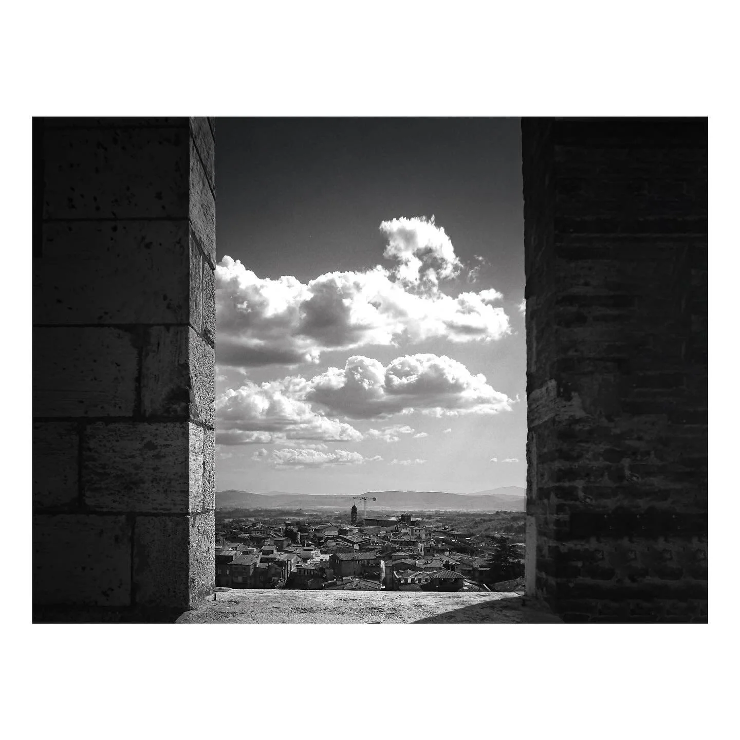 From elevated vantage points in Tuscany, medieval towns can be seen as a complex network of pitched terracotta roofs.  The castellations at the Palazzo Pubblico in the Campo in Siena frame this view across the town below perfectly. 

Tuscany
Siena
Pi