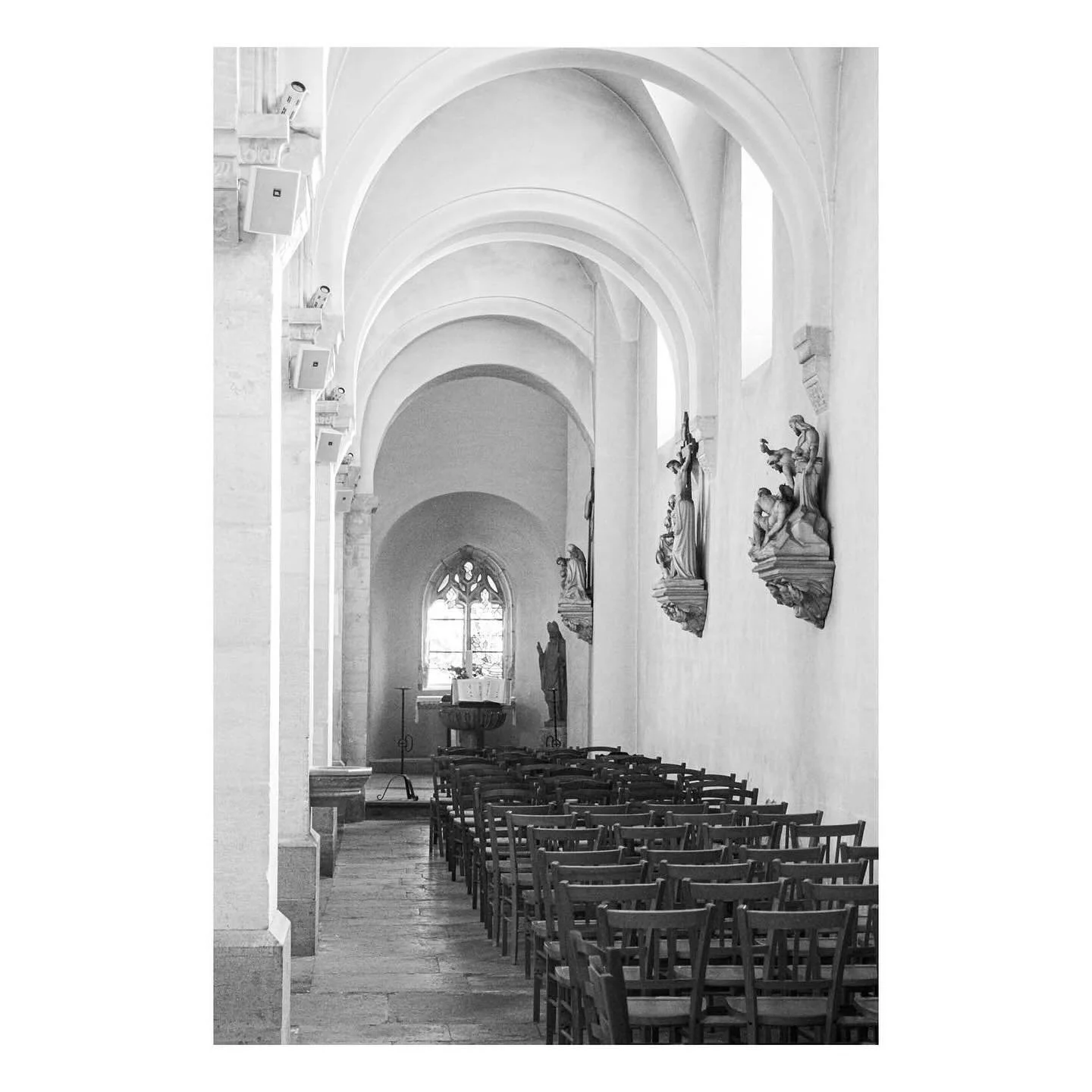 Intricately carved Stations of the Cross, mounted on the outer walls at L&rsquo;Eglise Saint-Germain in Buxy, Burgundy, align with the Romanesque arched ceiling. 

Aside from the prevalent arches, the interior is clean and otherwise restrained, drawi