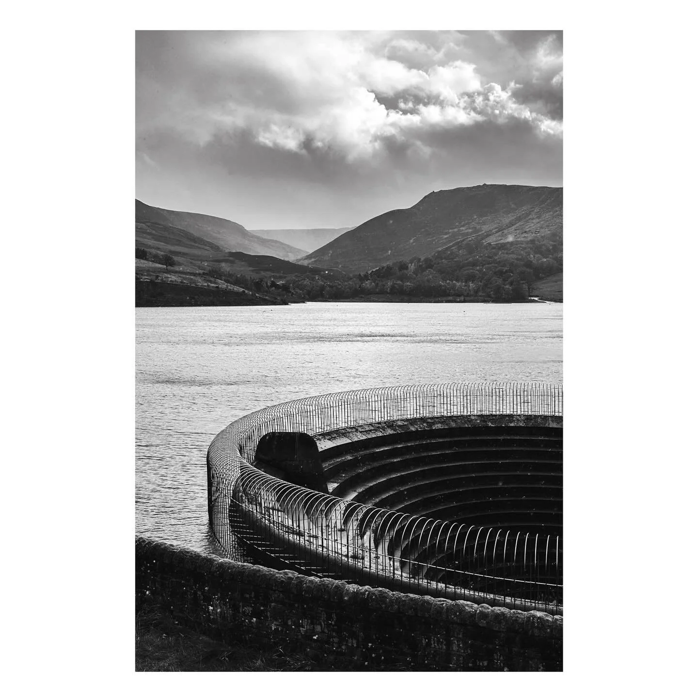 The strong circular geometry of the reservoir overflow sets a muscular contrast with the hills that surround the Dovestone Reservoir on Saddleworth Moor above the Village of Greenfield on the western edge of the Peak District National Park.

#reservo