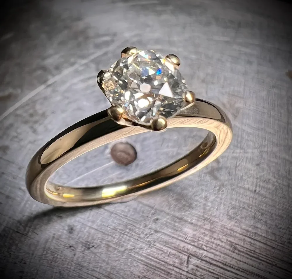 Verlobungsring 6er Krappe aus recyceltem Gold mit einem Diamanten im old cut 