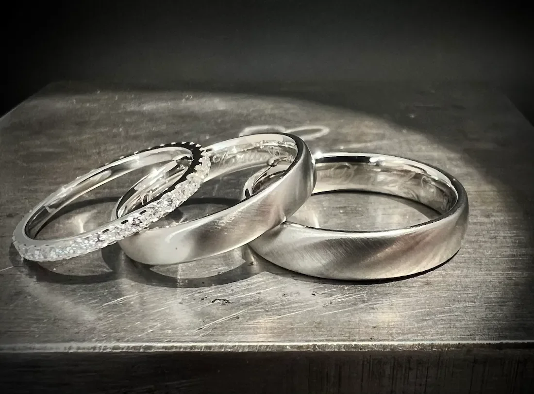 Drei Silberschmuckringe auf einer Holzoberfläche