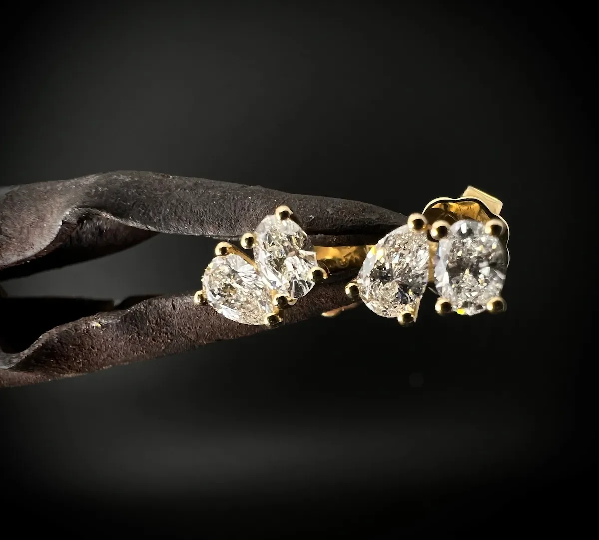 Zwei Paar Fancy cut toi et moi Diamanten Ohrringe mit goldenen Fassungen auf einem schwarzen Hintergrund.