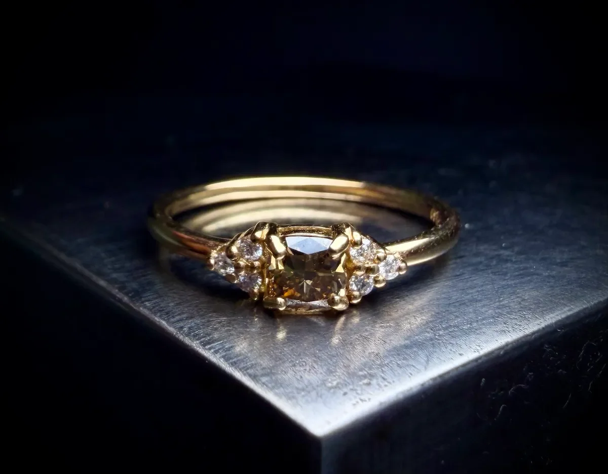 Besonderer Verlobungsring aus Gelbgold mit braunem Diamanten und seitlichen Brillanten, München.