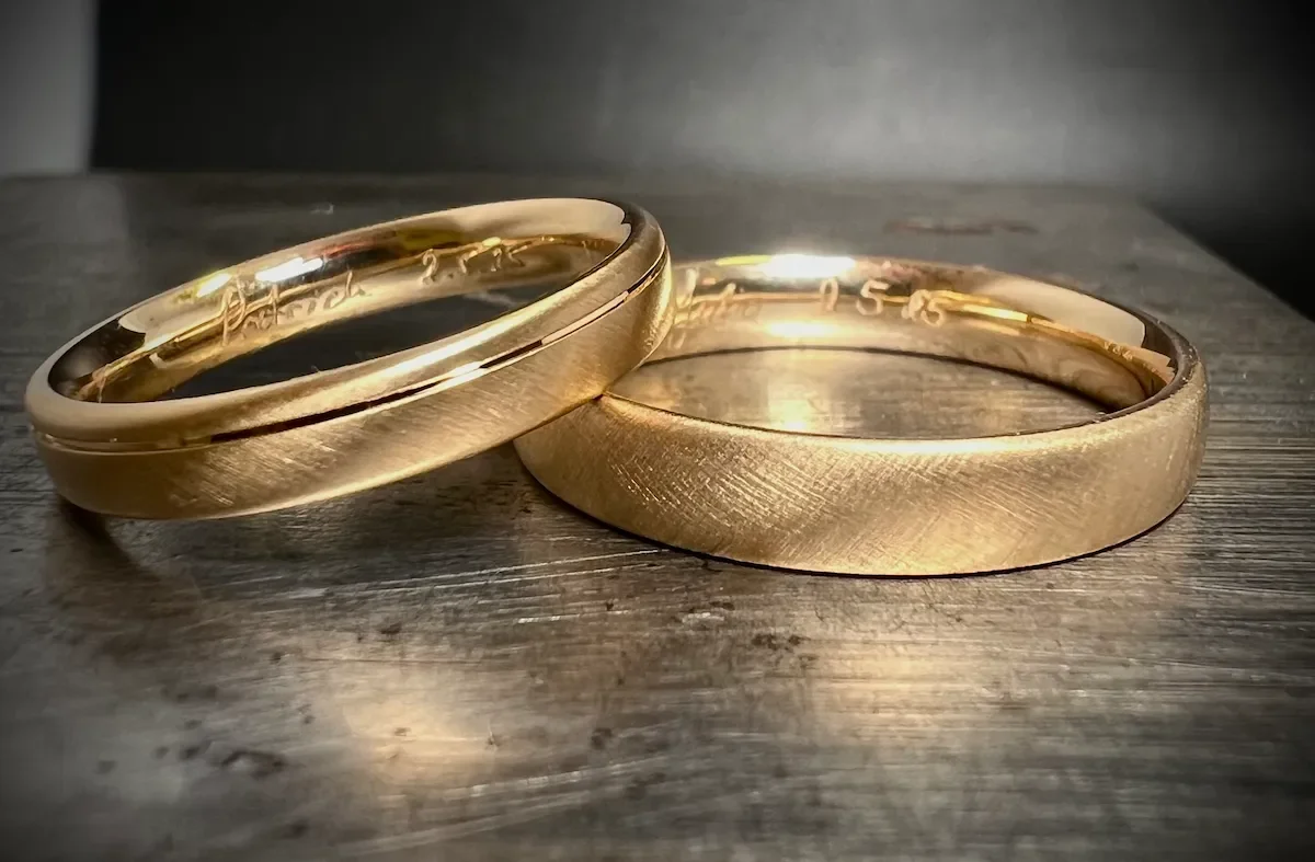 Zwei goldene Eheringe auf einem Holz Tisch