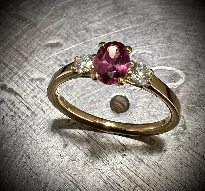 Trilogie Verlobungsring aus Gelbgold mit pinkem Saphir und zwei Diamanten, Handarbeit aus München.