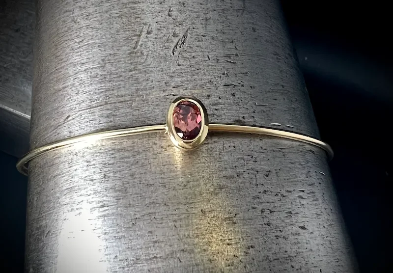 Goldarmreif mit leicht roten Saphir