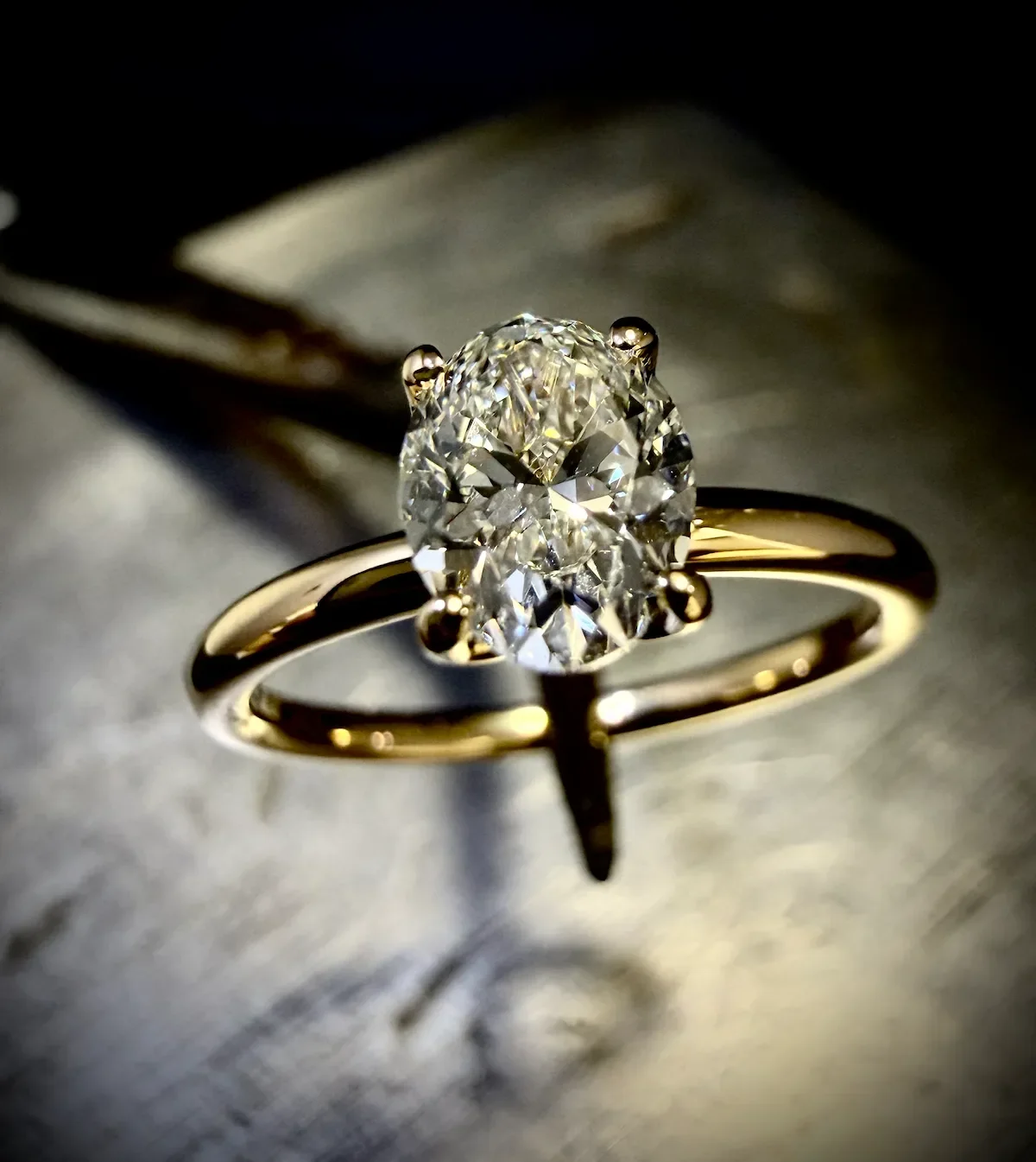 Eleganter Gelbgold-Verlobungsring mit ovalem Diamanten in feiner 4-Krappen-Fassung.