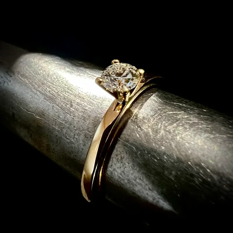 Verlobungsring mit 4er Krappe, aufgesetzt damit man ihn optimal zum Ehering tragen kann aus Gelbgold mit einem Diamanten 