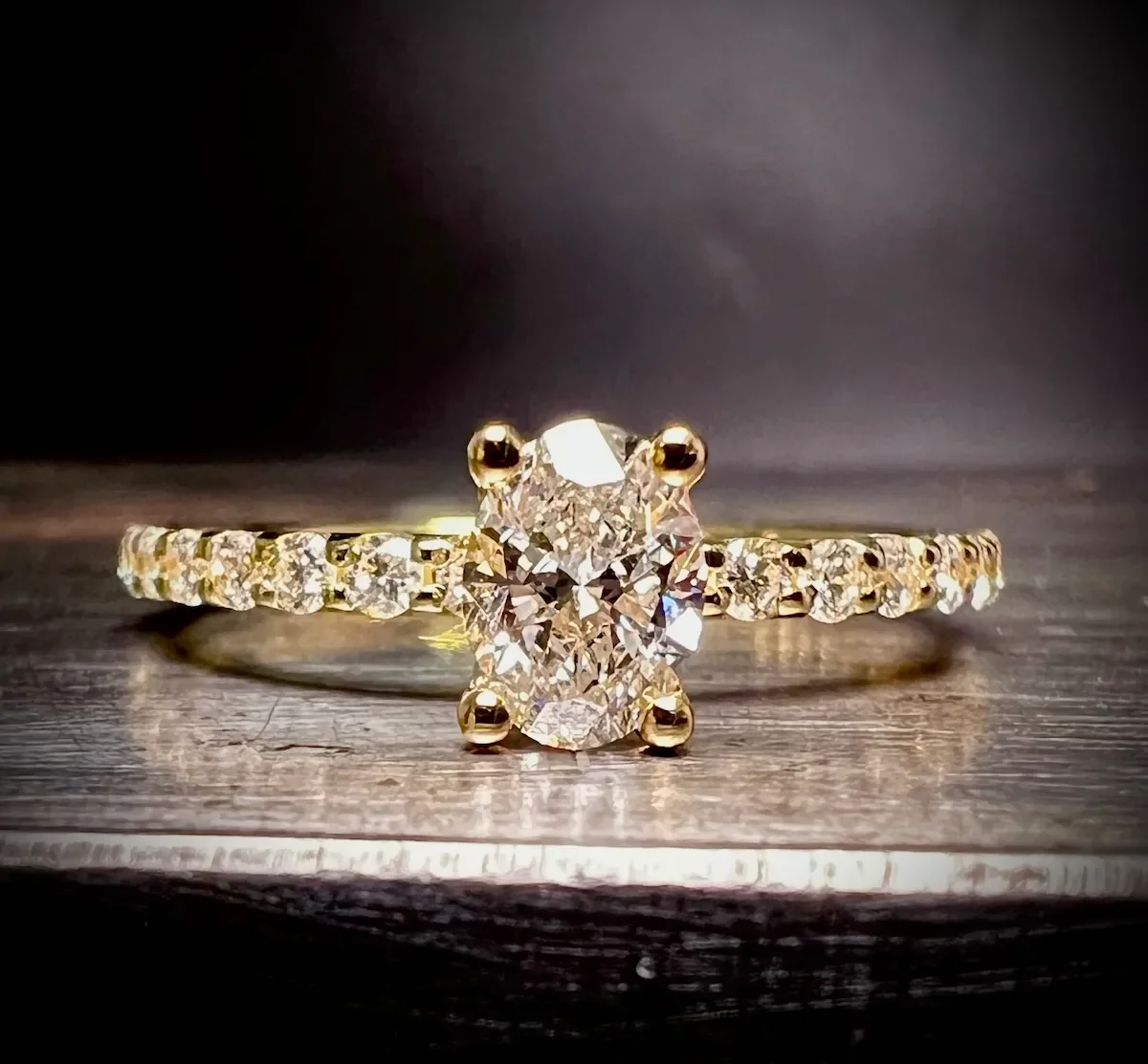 Verlobungsring aus Gelbgold mit ovalem Diamanten und rundum besetzter Diamantschiene, Isarschmiede München.