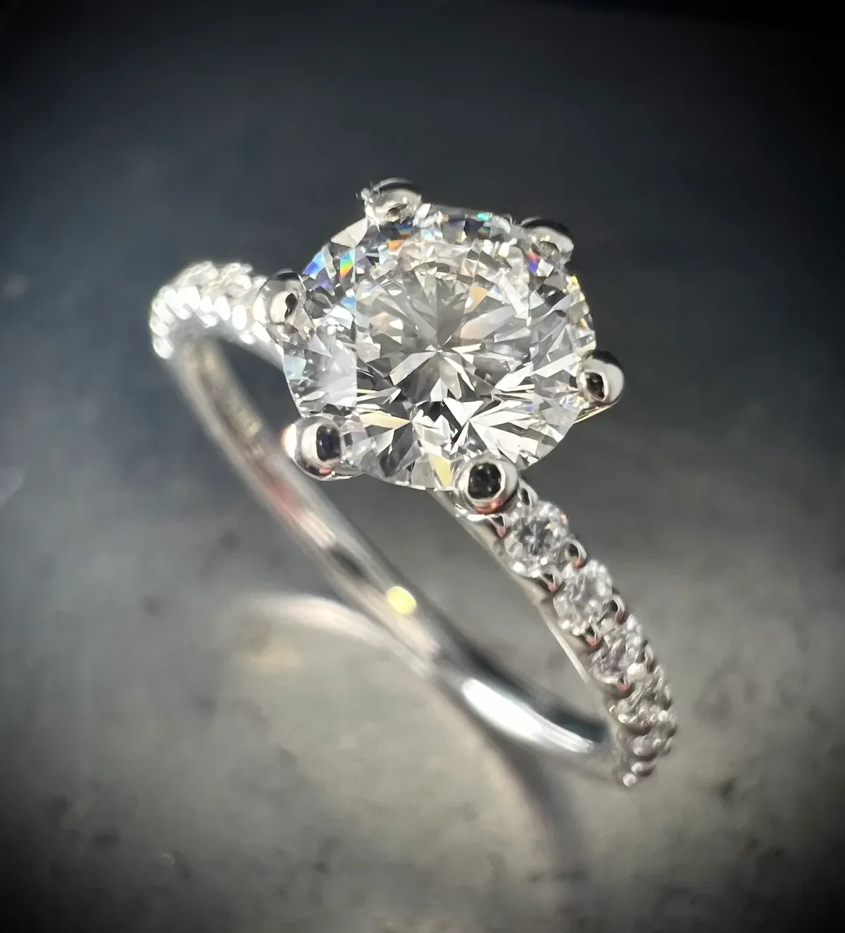 Platin-Verlobungsring mit rundem Brillanten und rundum besetzter Diamantschiene, München.